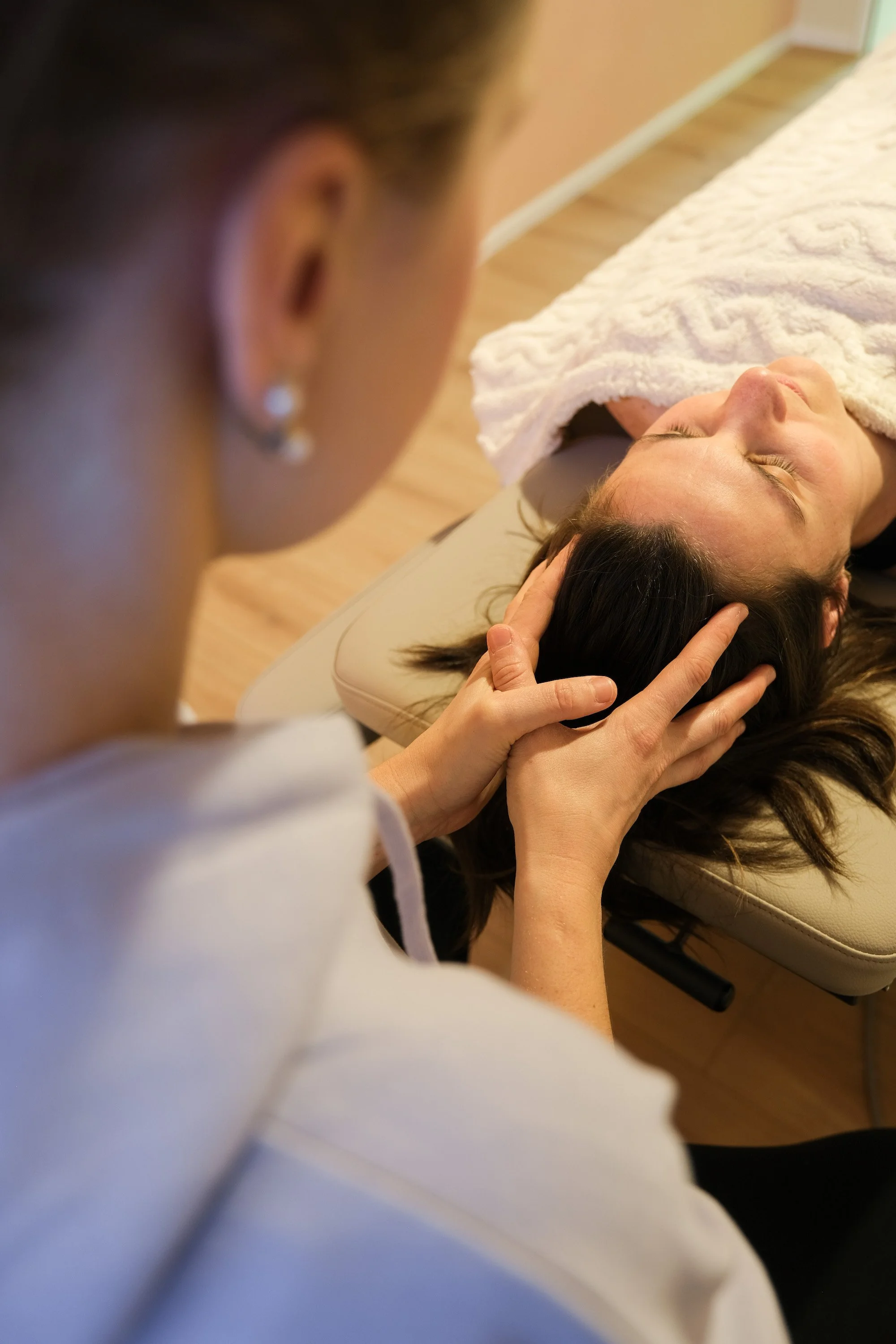 Eine Therapeutin behandelt eine Patientin osteopathisch am Kopf im Gesundheitsatelier Aruna in Remerschen