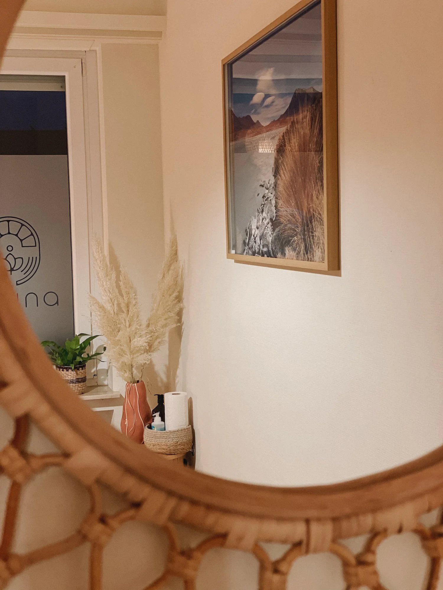 Ein Teil eines Behandlungsraumes für Osteopathie und Kinésithérapie mit einem Bild an der Wand und einer Boho Einrichtung.