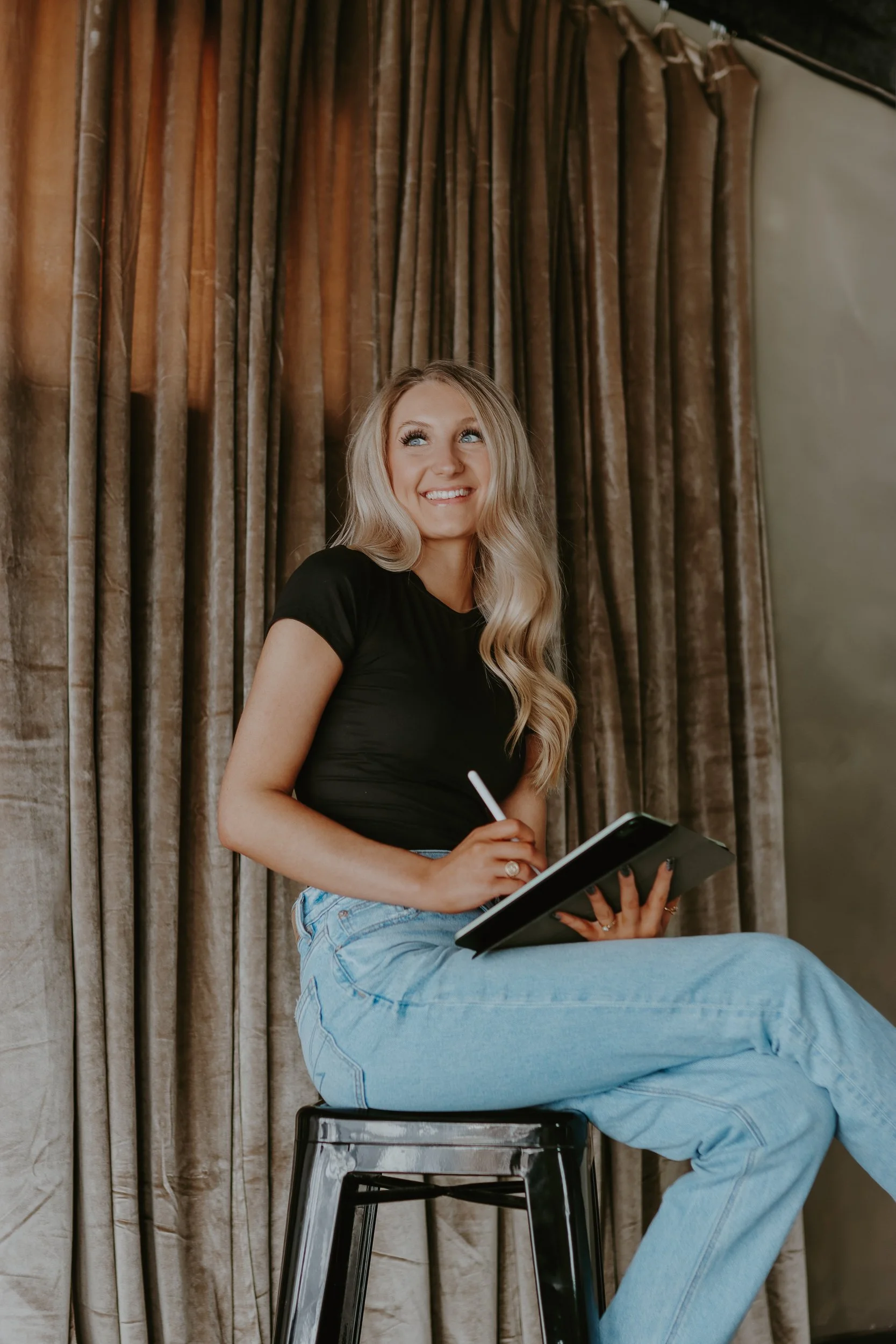 Sydney, designer behind StudioSyd, sitting with an iPad during a branding photoshoot.