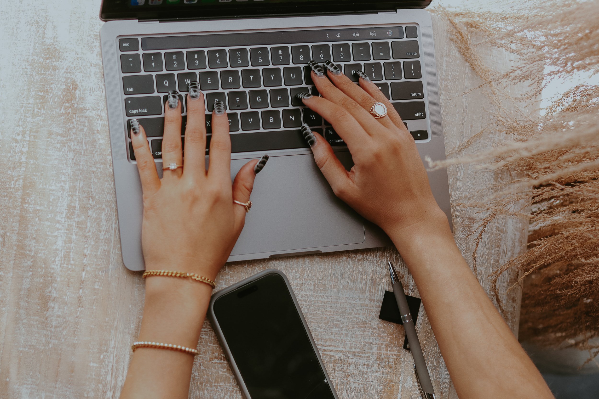 Hands working on a laptop during a creative design project.