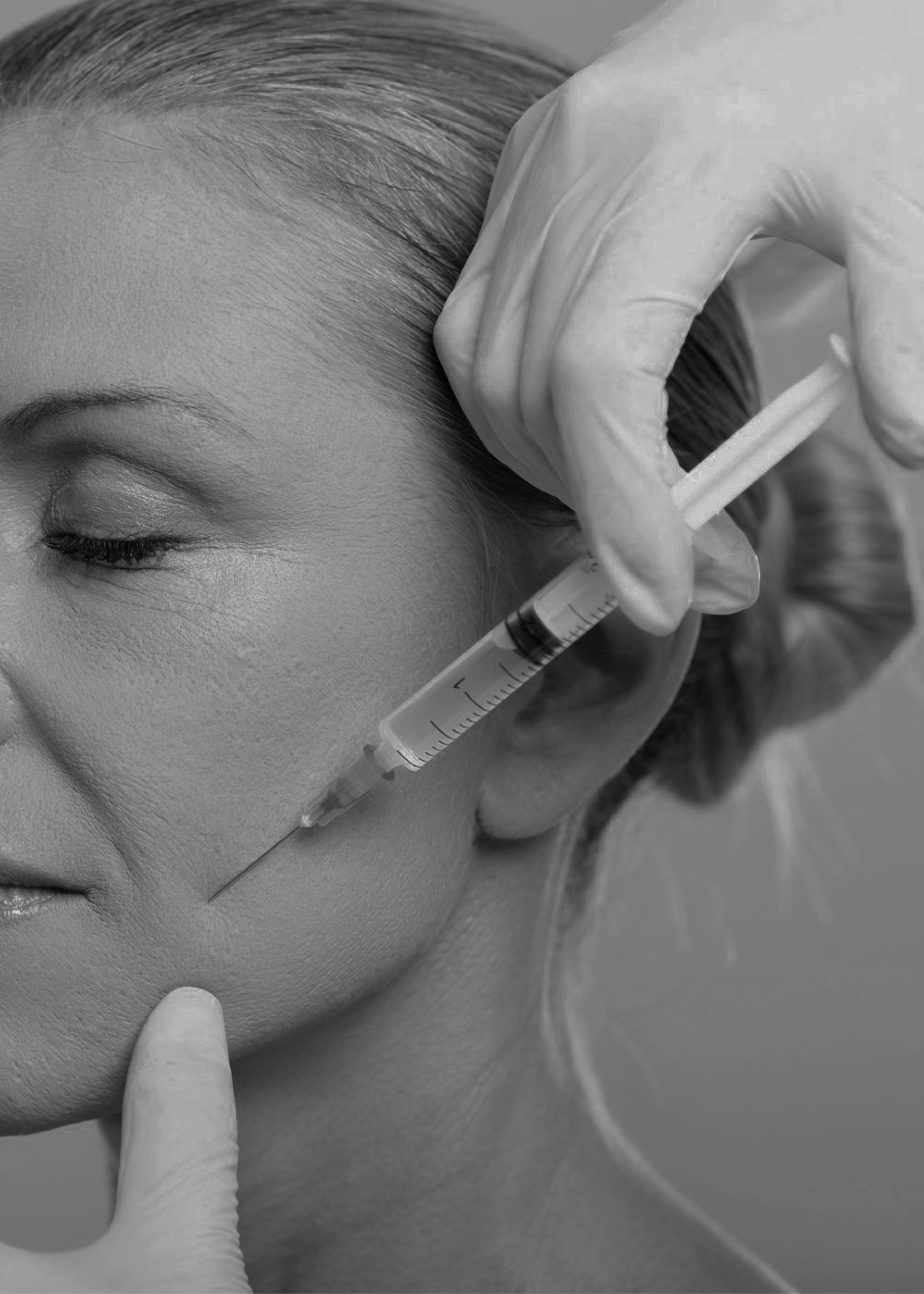 A woman receiving a facial injection from a medical professional wearing gloves.