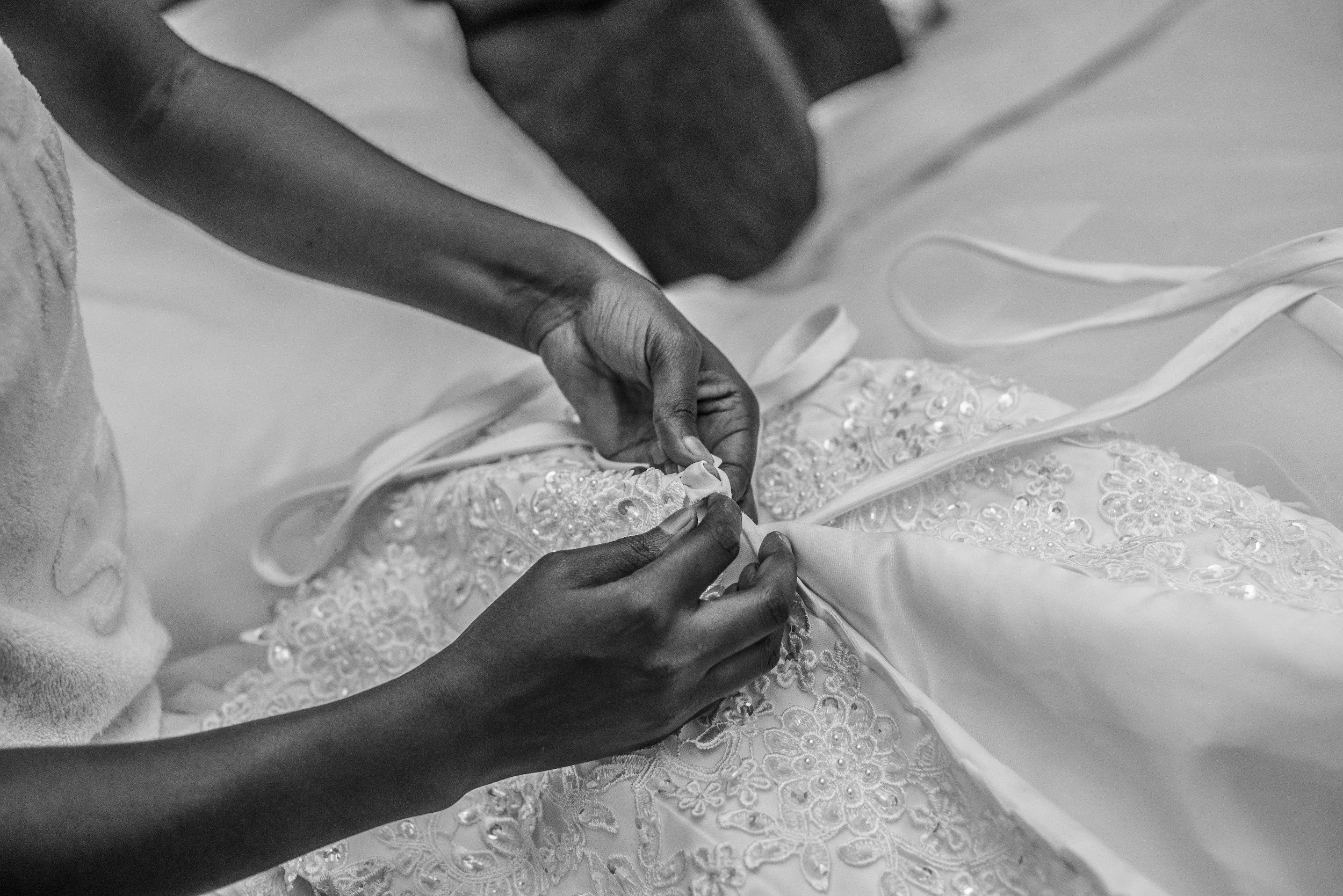 Seamstress pinning a lace wedding gown during bridal alterations in Torrance