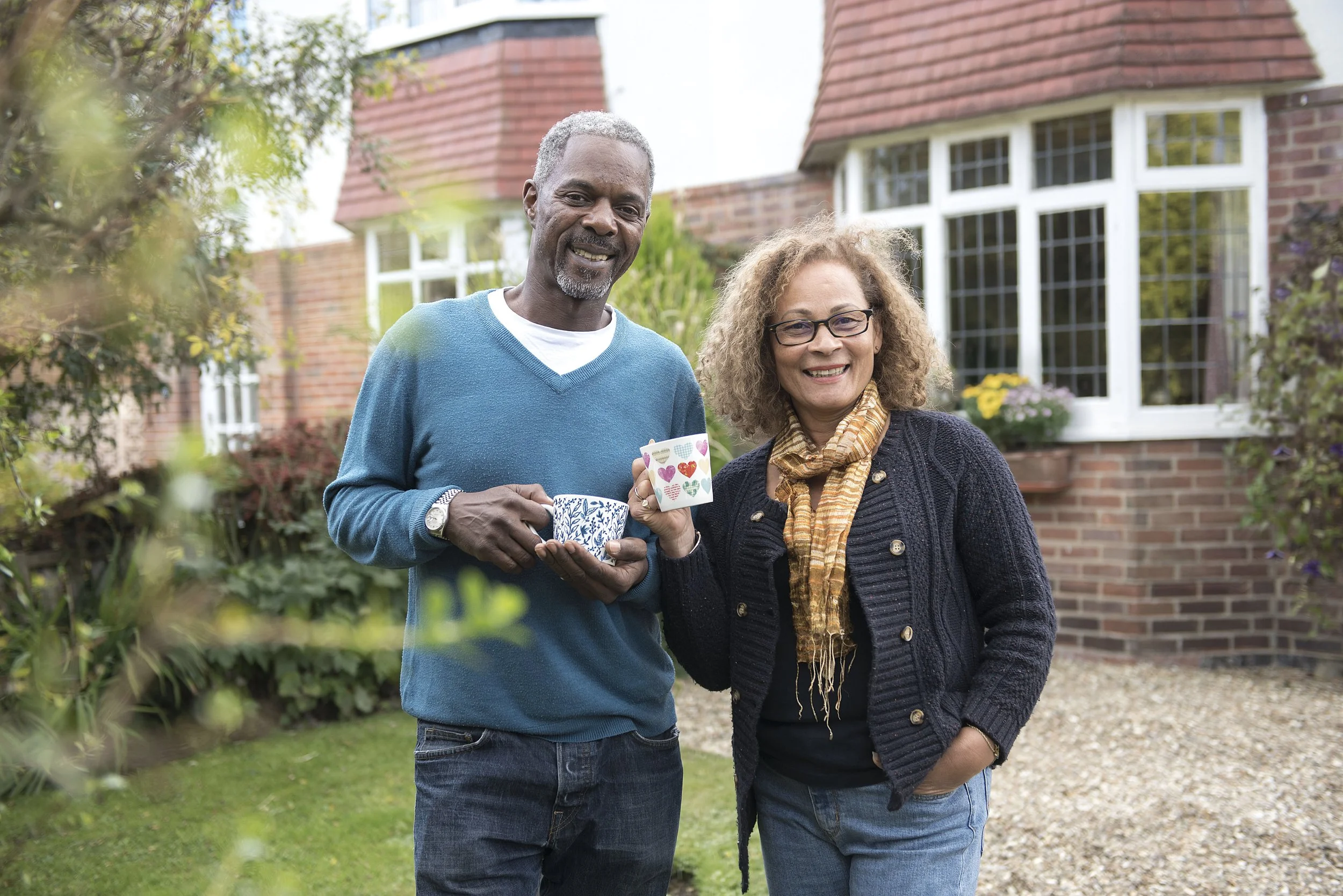 a man and woman stood in front of their semi detached house in Leeds