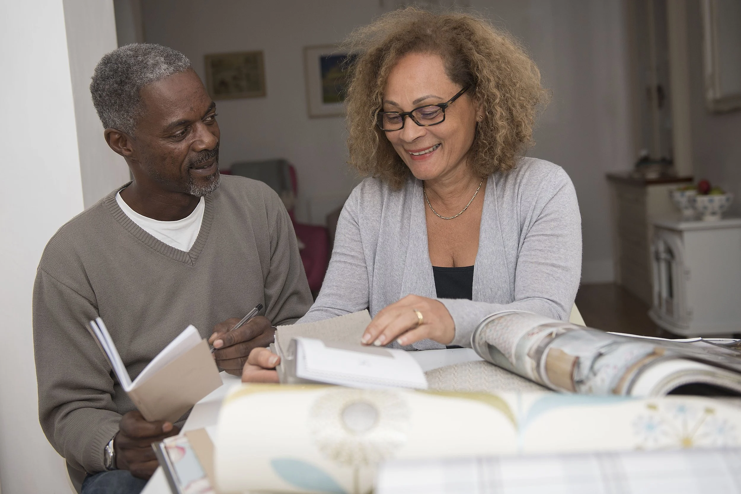 man and woman looking through home decorating items in the kitchen of their home in Leeds