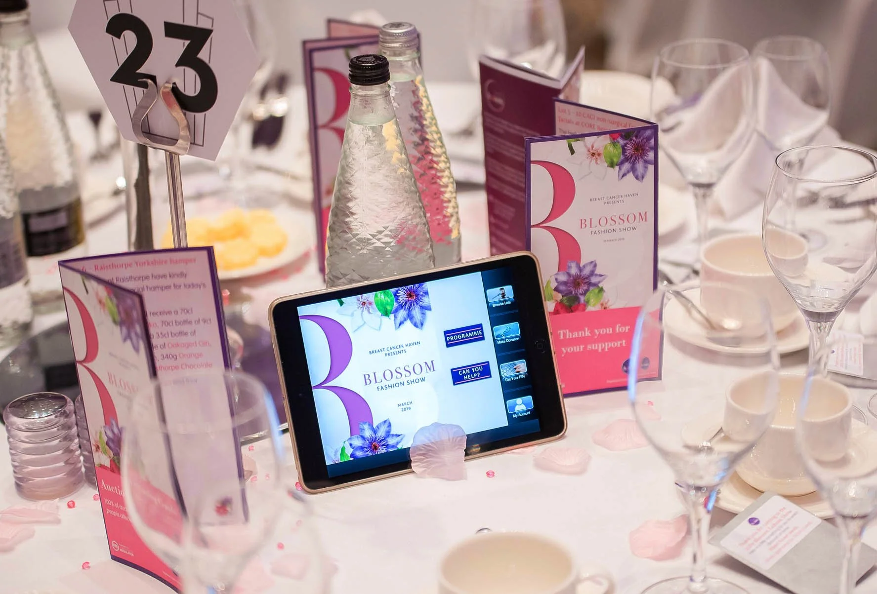 charity ball close up of a table with leaflets, glasses and cups and sauces. Breast cancer Haven Leeds