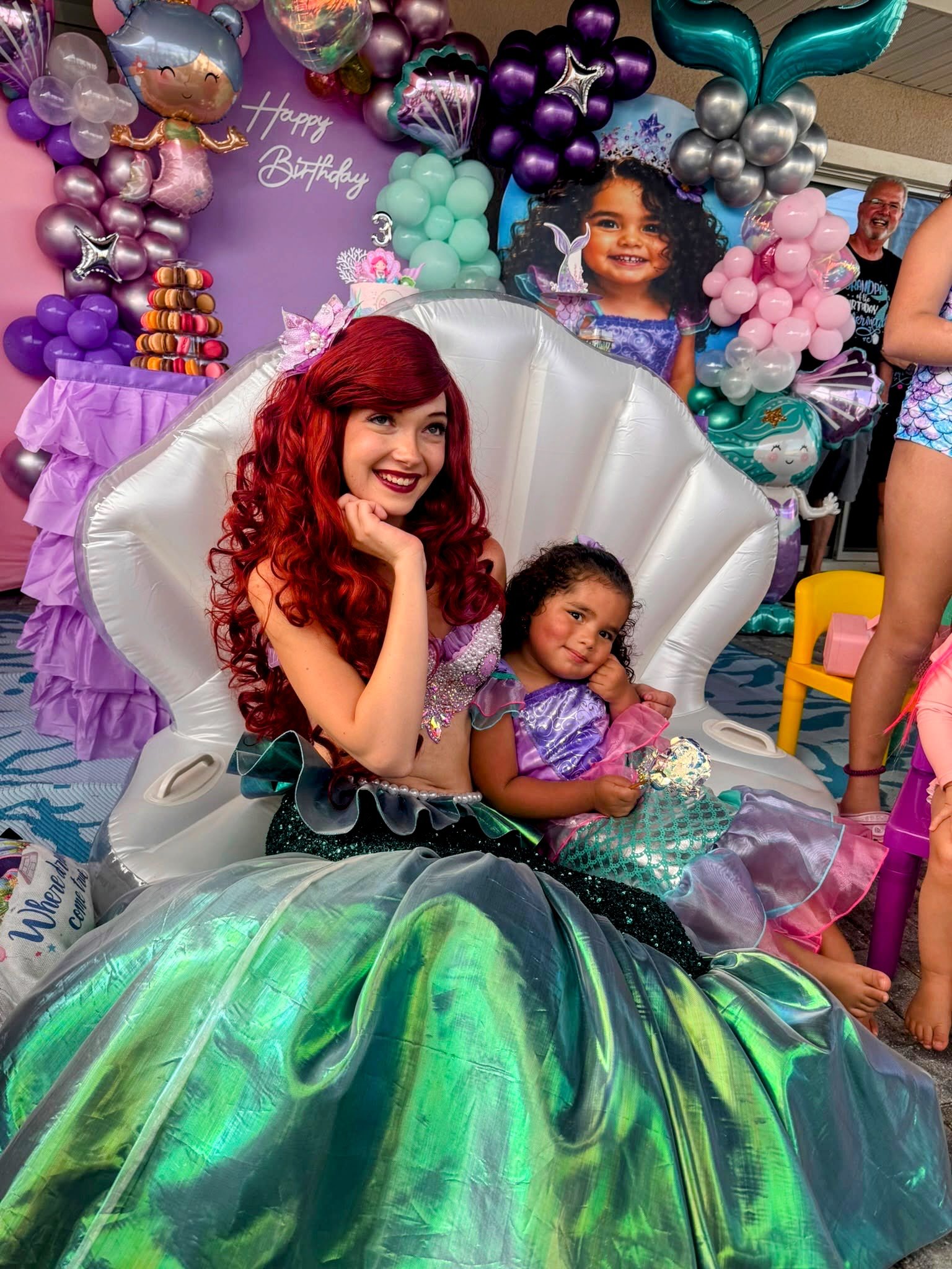 The little mermaid sitting with a birthday girl in a large decorative shell at a Kids Birthday Party in Tampa.