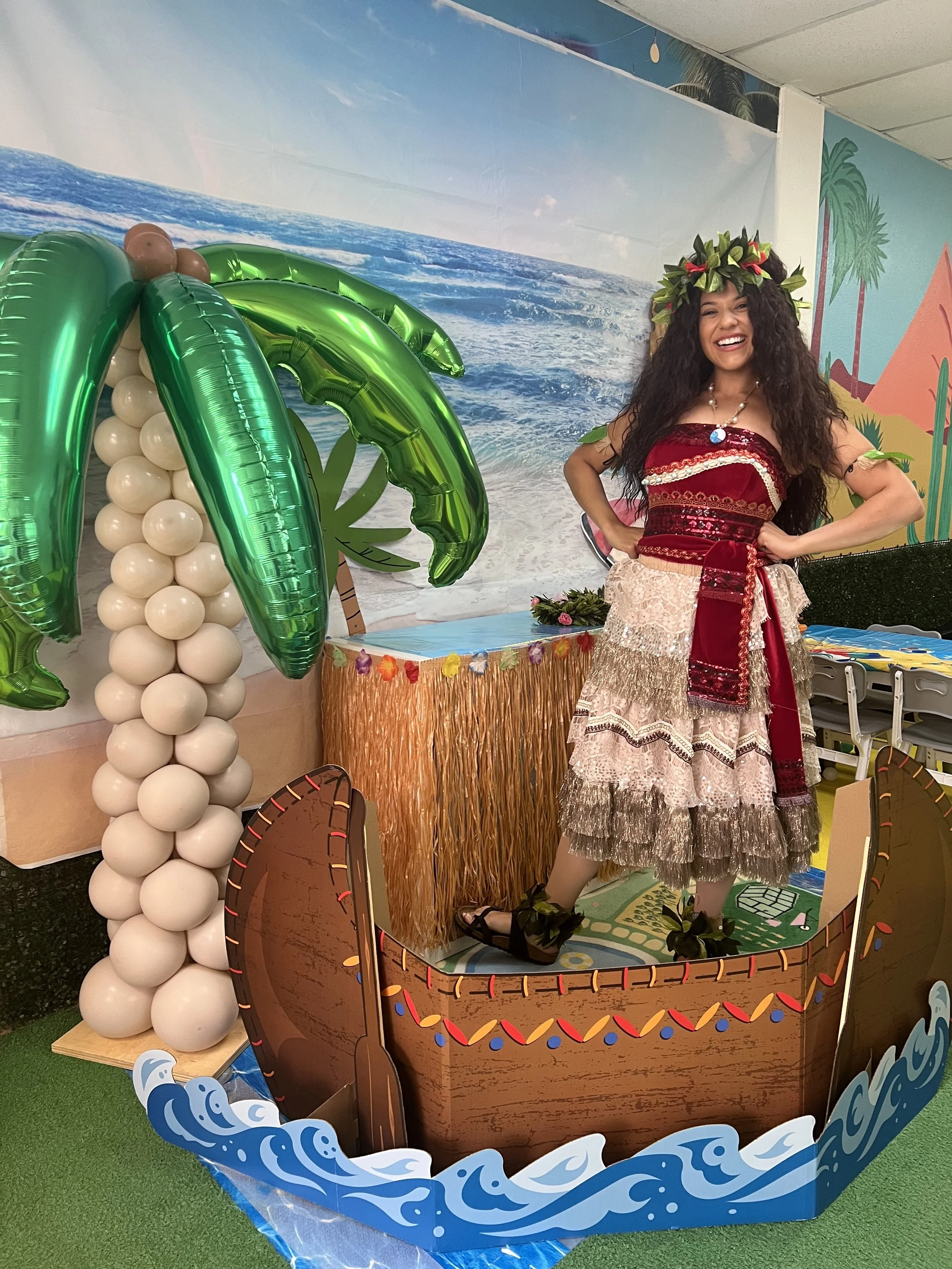 Moana standing in a Canoe by a Palm Tree at a Party Place event party in Tampa.