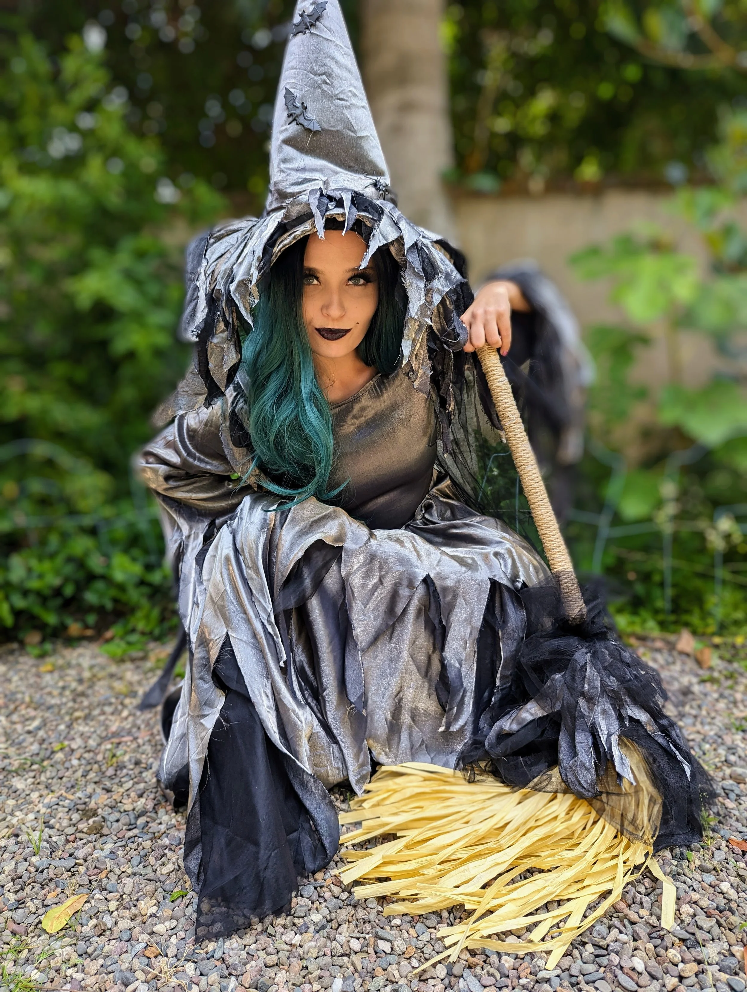 Silver witch with green blue hair holding her broomstick