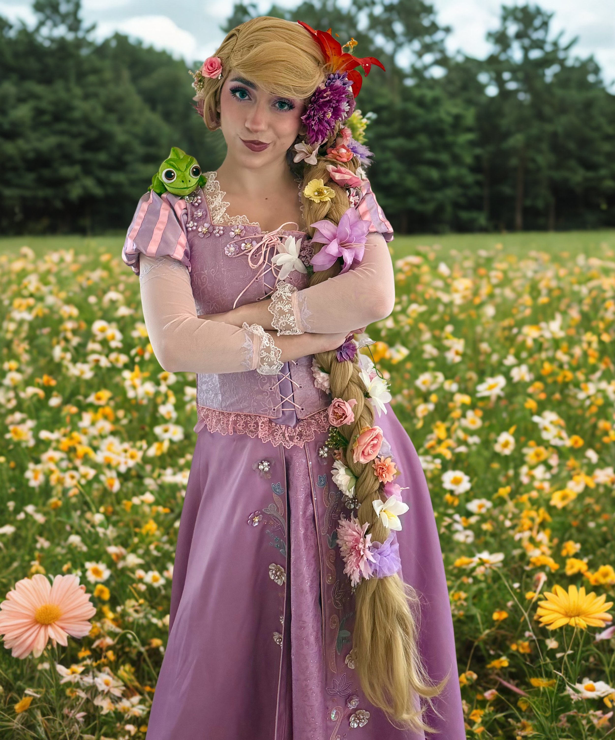 Rapunzel at a princess party in Tampa stands in a field of yellow and pink flowers with trees and cloudy sky in the background.
