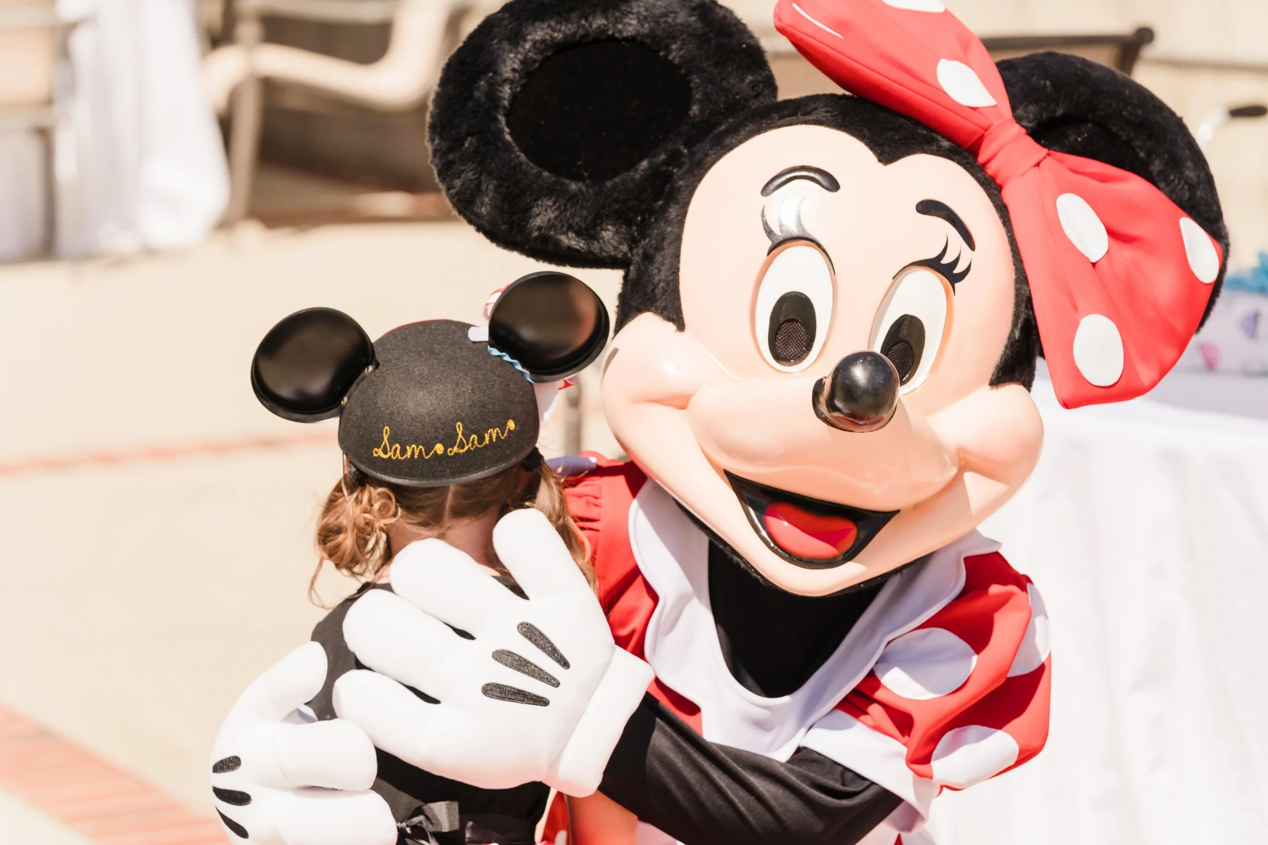 Minnie Mouse giving a little girl a big hug
