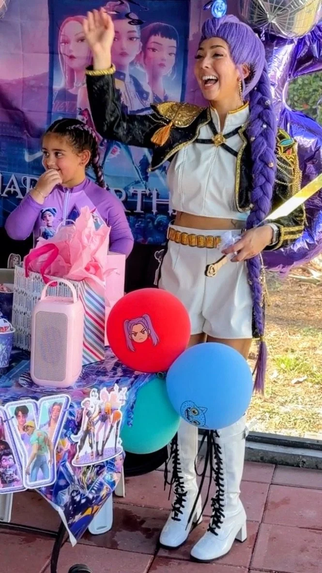 Rumi K-pop Demon Hunter performer at a fun dance birthday party celebration surrounded by balloons and kids