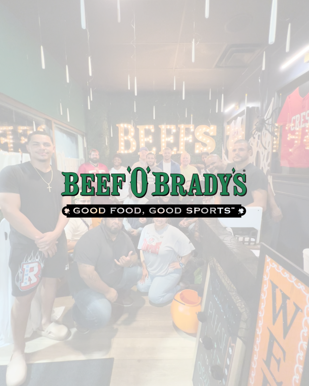 Inside a restaurant named BEEF'O BRADY'S with people standing and sitting, decorative lighting, and signs, including a large illuminated BEEF'S sign in the background.