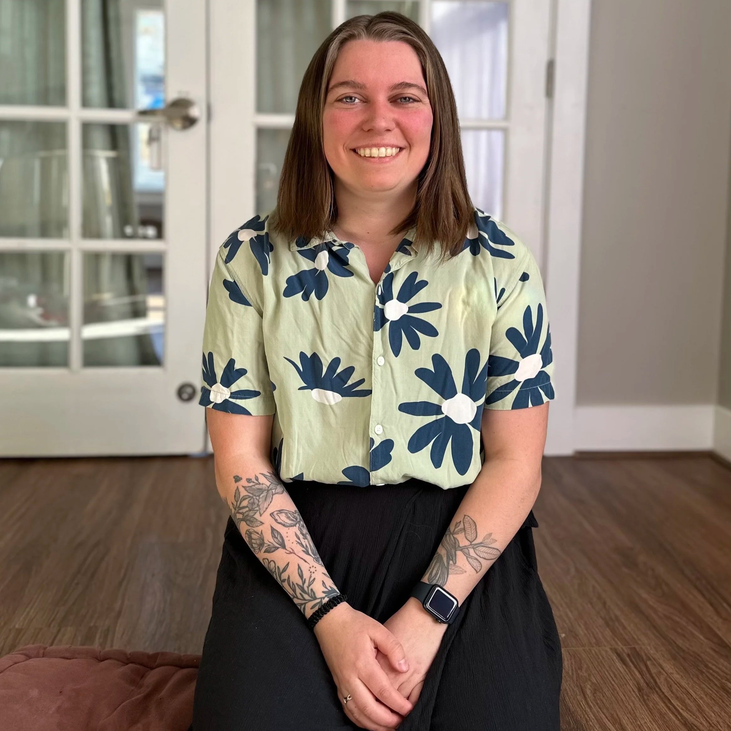 Photo of women wearing a floral shirt with should length brown hair