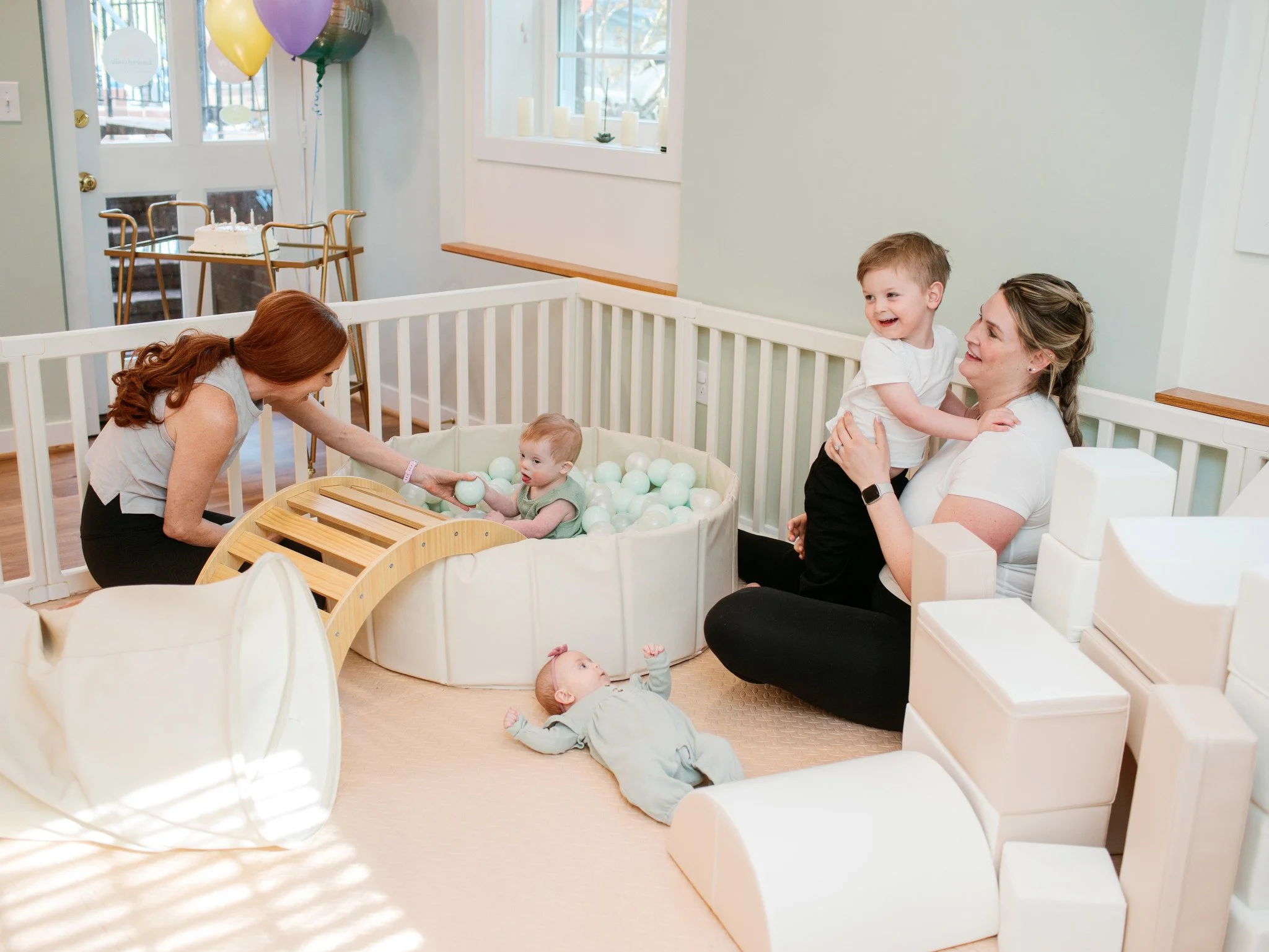 White woman with brown hair on a yoga mat doing a bridge with her baby on her belly