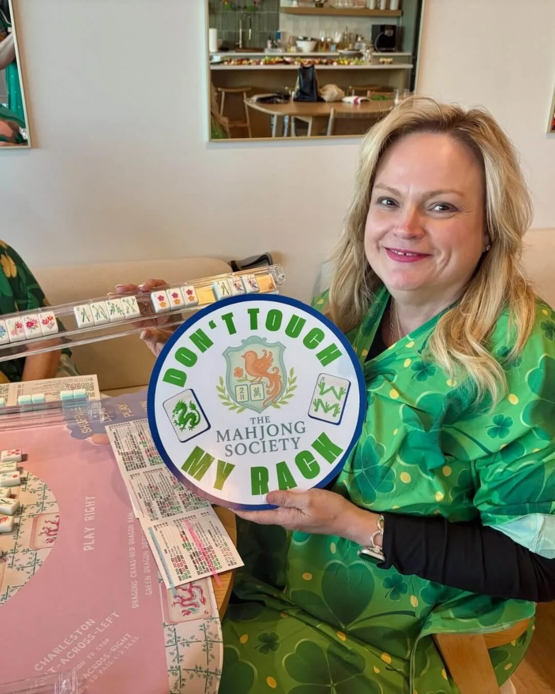 Woman playing Mahjong holding a sign that says "don't touch my rack"