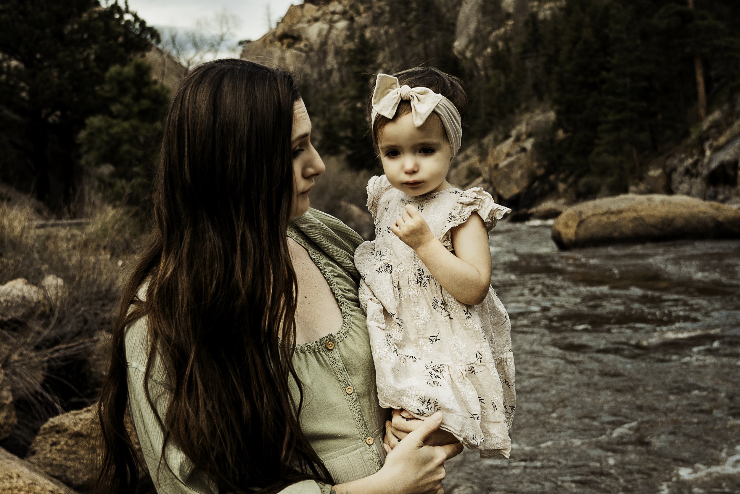 Mother holding her daughter by the river