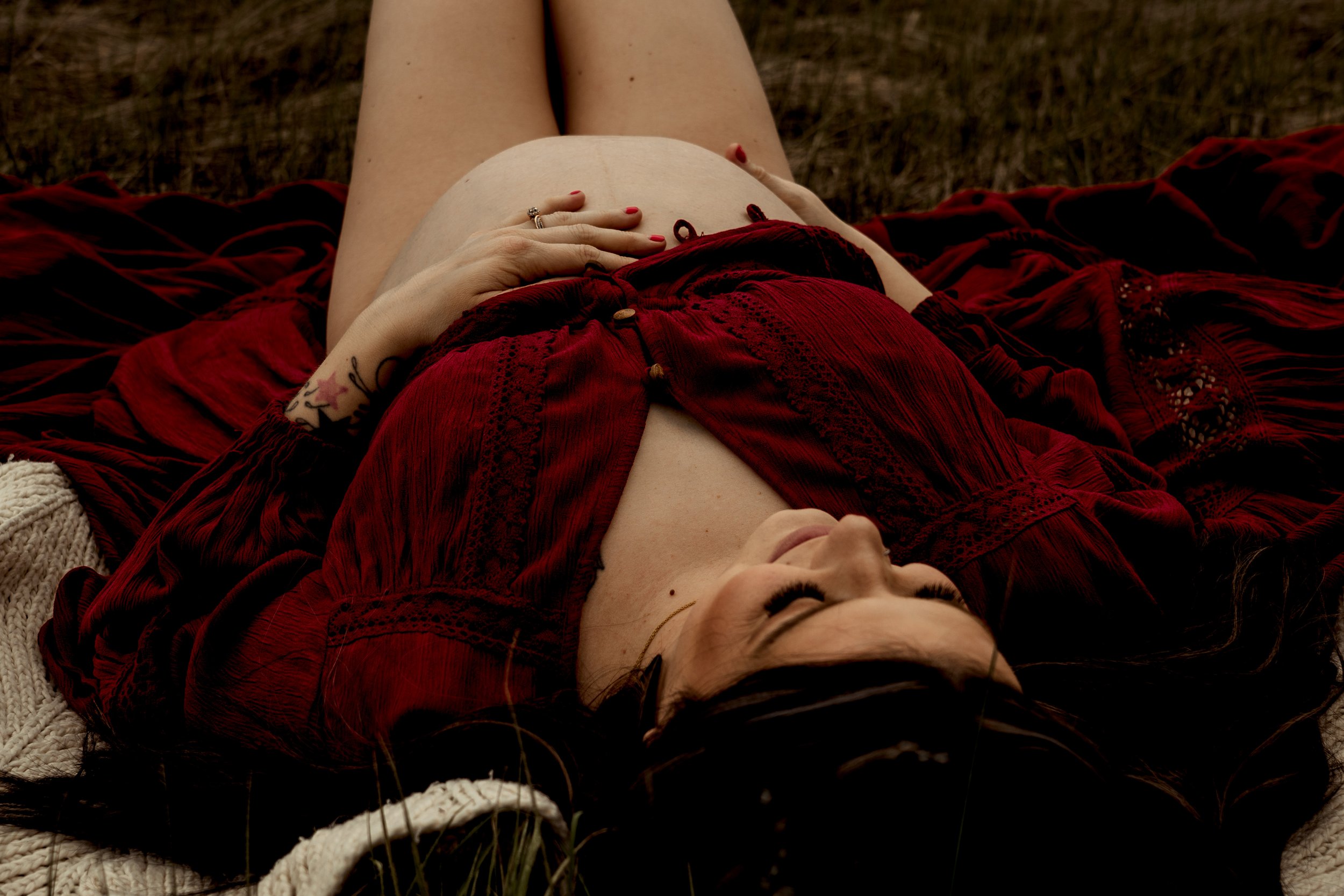 Momma to be laying down embracing her growing belly