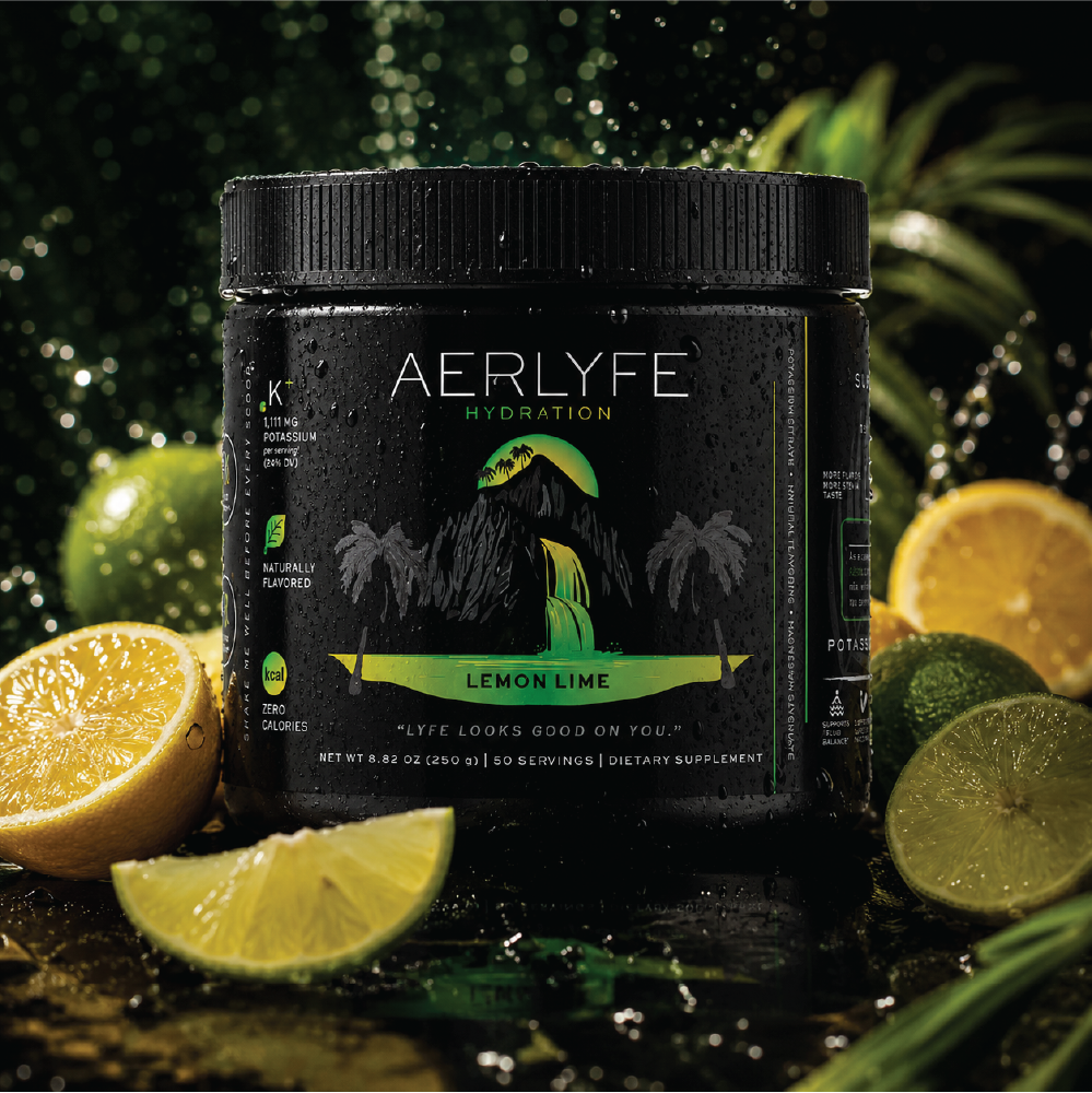 A black container labeled 'AERLYFE Hydration Lemon Lime' surrounded by sliced lemons and limes on a wet surface with a blurred outdoor background.