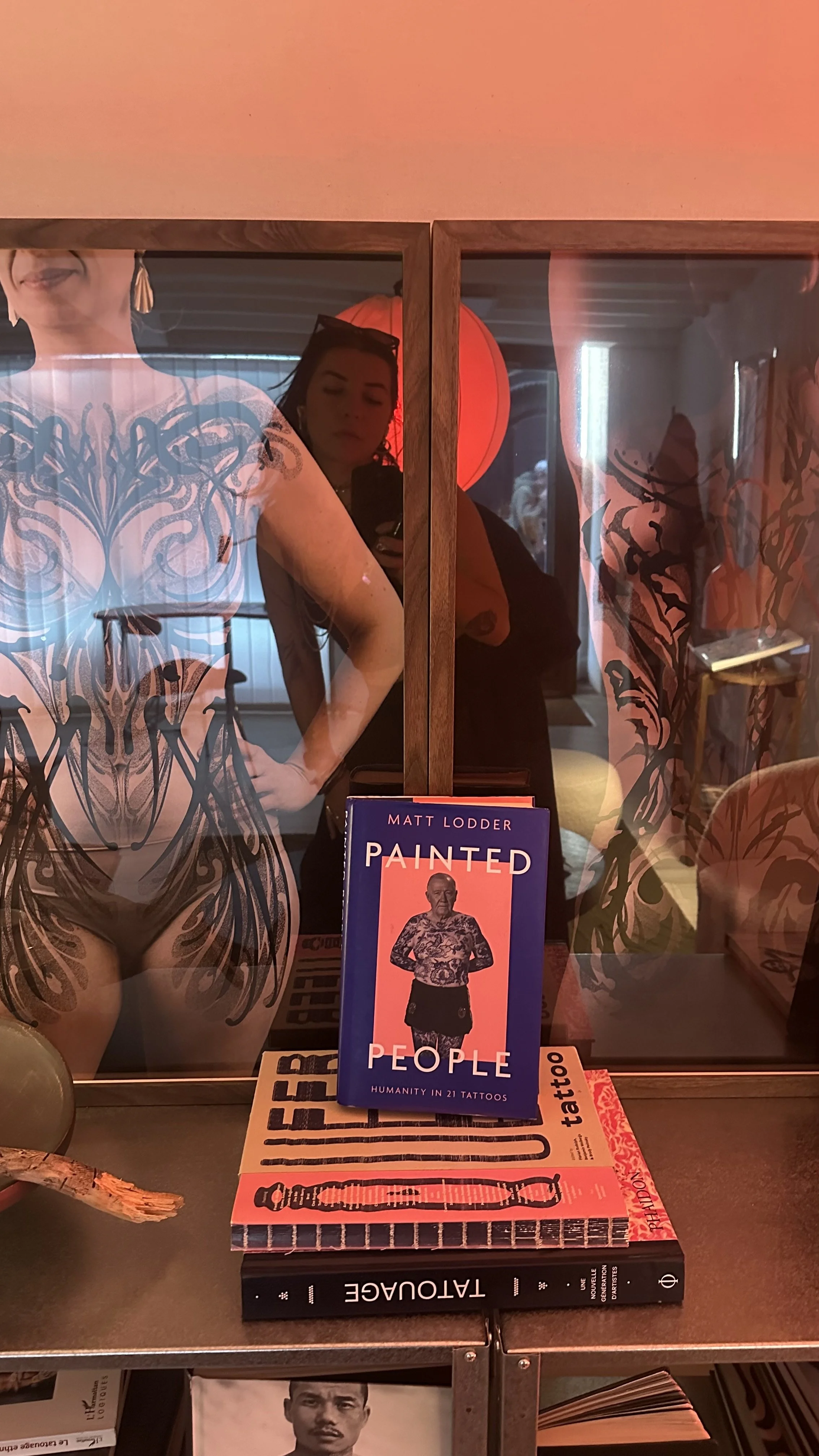 Coriolis dans son atelier de tatouage privé, entourée de livres d'art tatouage