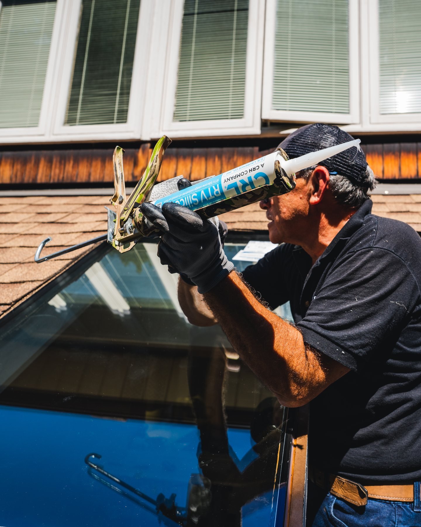 A WRE technician applying silicone to seal a window perimeter against water and drafts