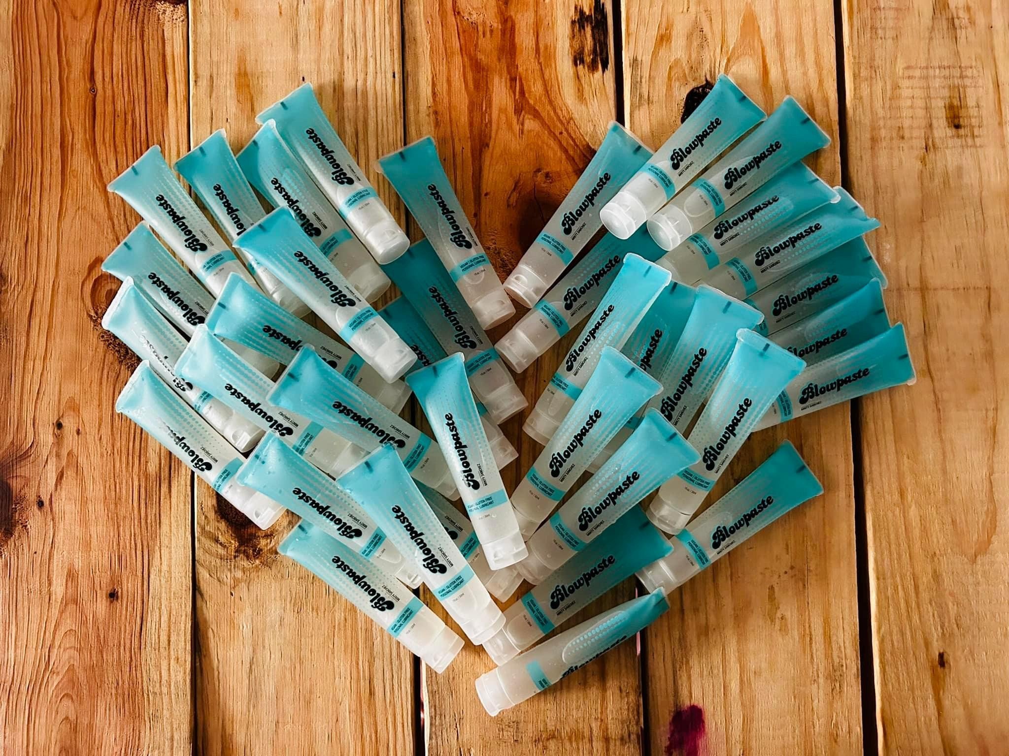 Blowpaste Minty Sanchez edible vegan mint flavored personal lubricant, a multitude of 1oz tubes arranged into a heart shape and ready to sell