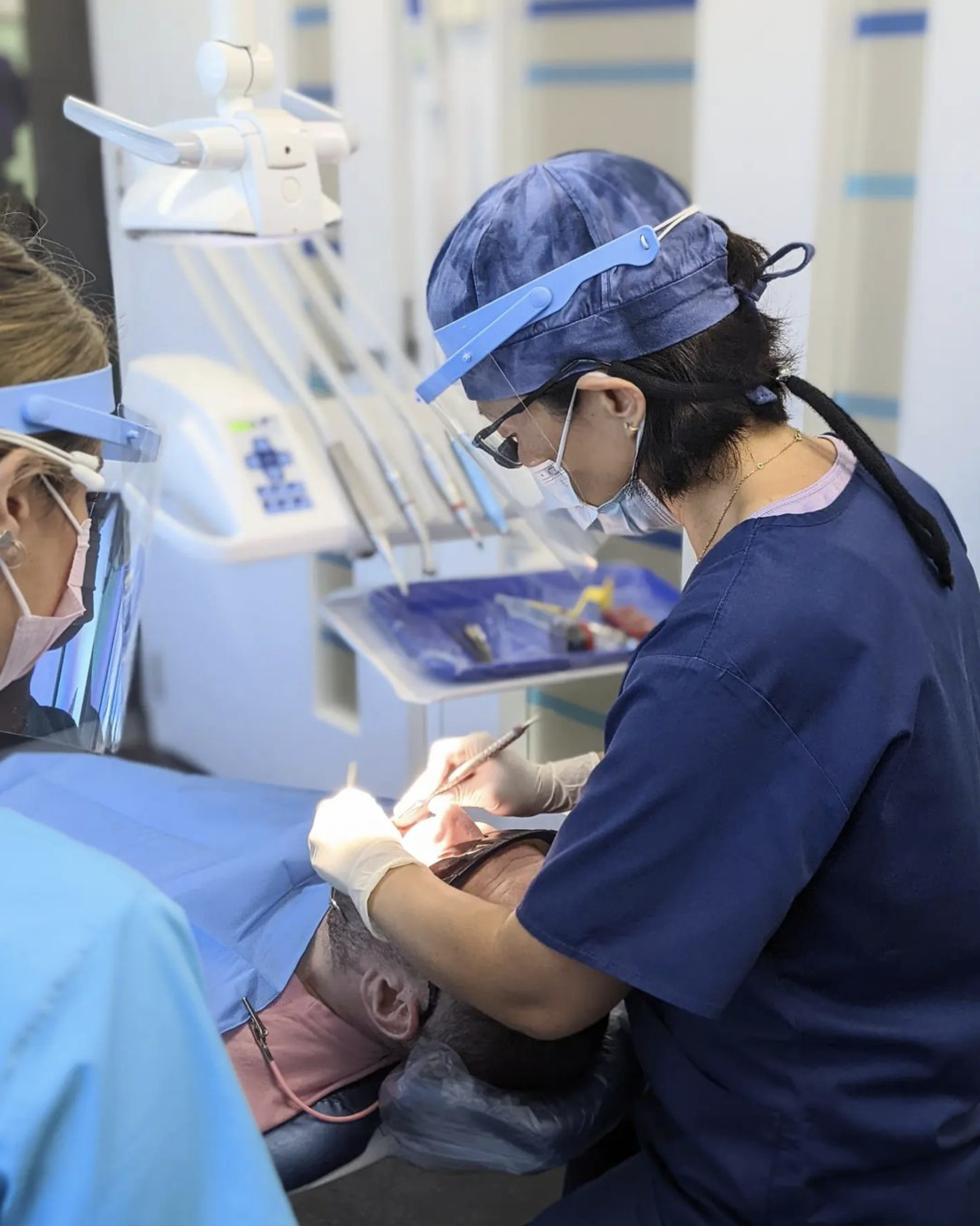 Dentist performing a dental procedure on a patient at Dee Why Dental, showcasing the process for placing crowns and bridges.
