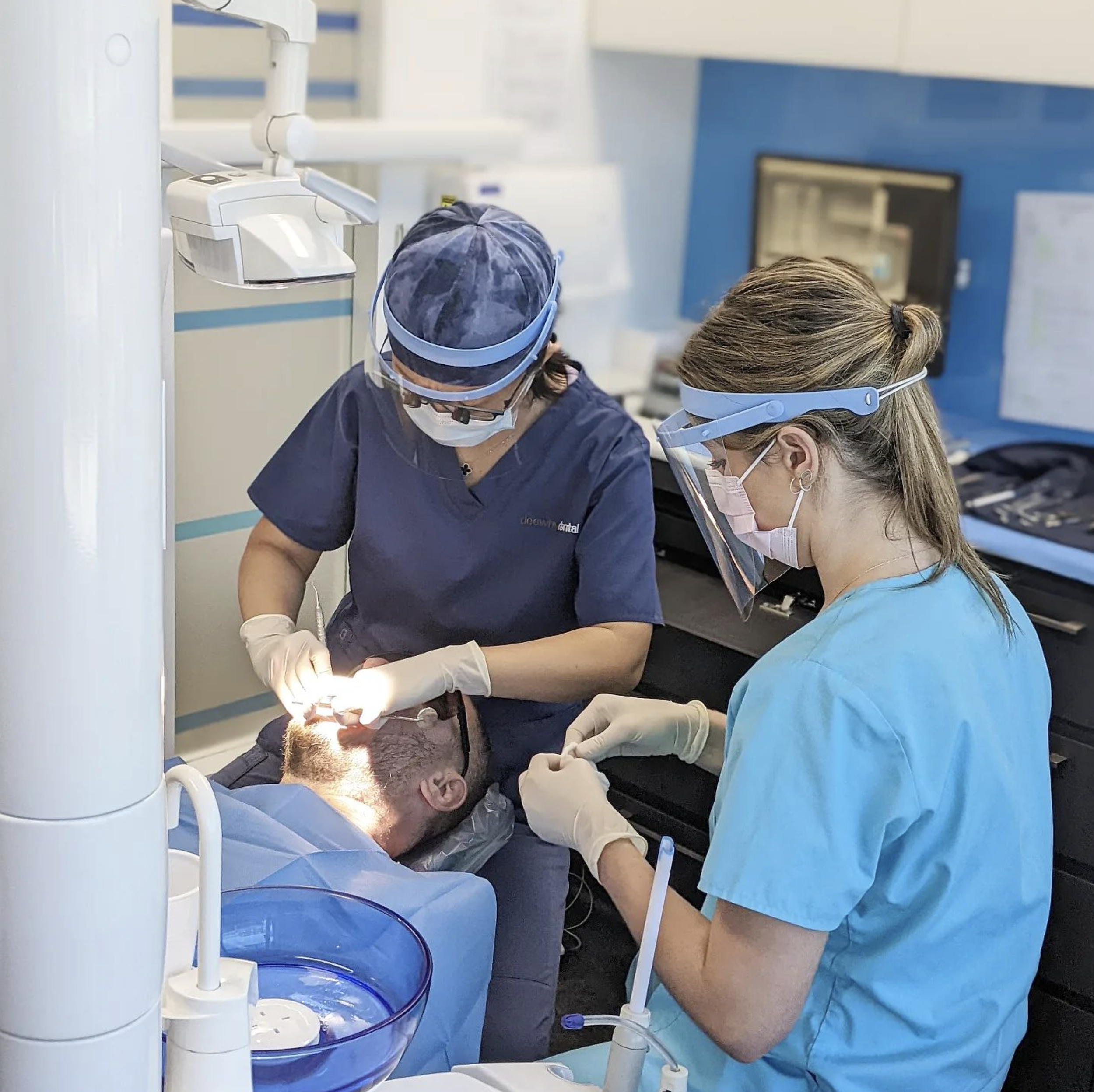 Dentists performing a dental cleaning procedure, showing the thorough care provided at Dee Why Dental.