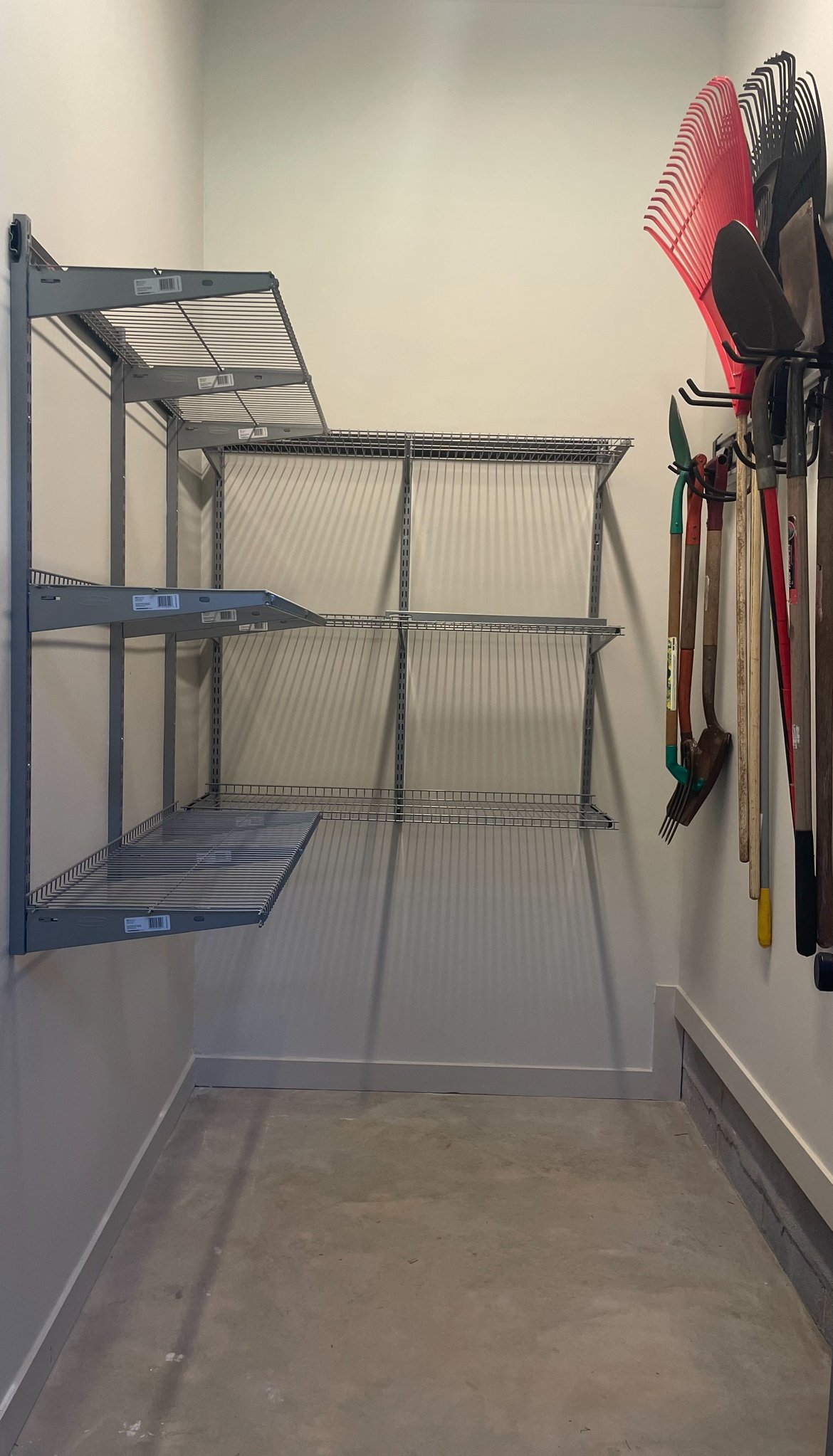 Empty storage room with wire shelves and garden tools assembled by professional organizers