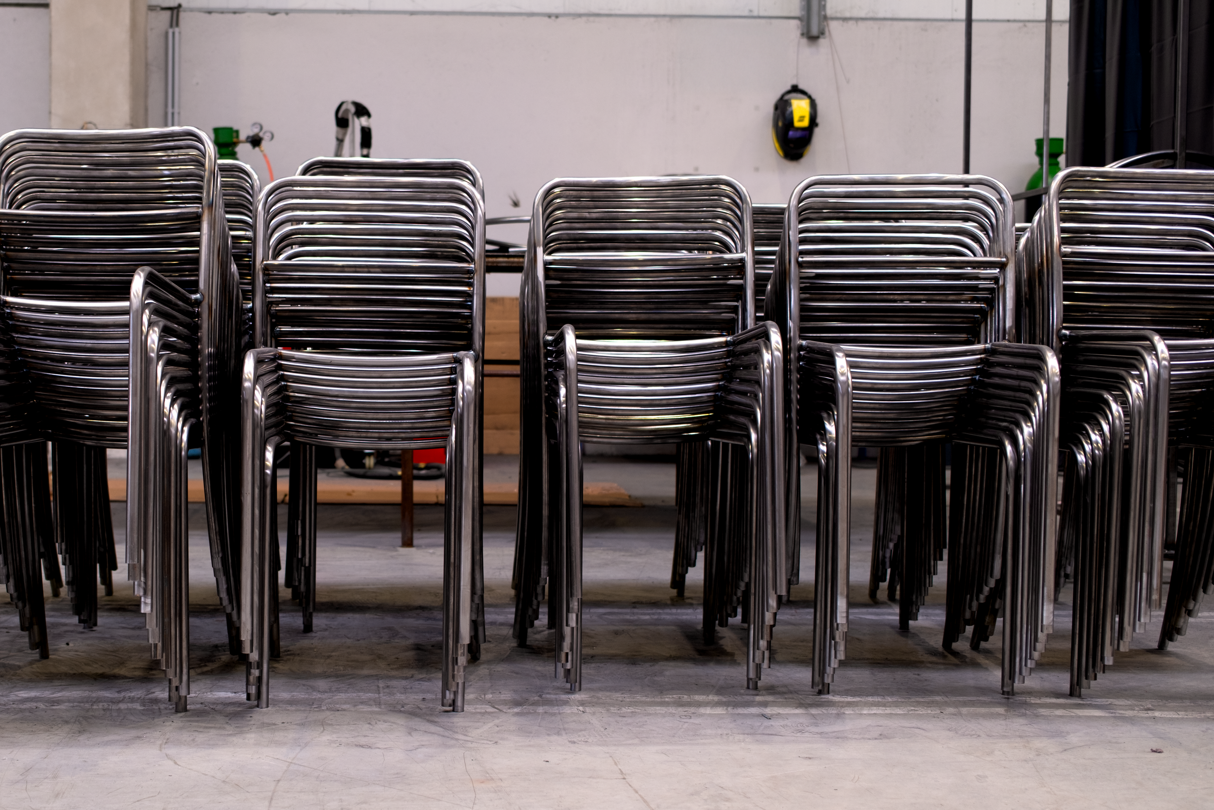 Chaise en métal empilées dans un espace de stockage ou de fabrication.