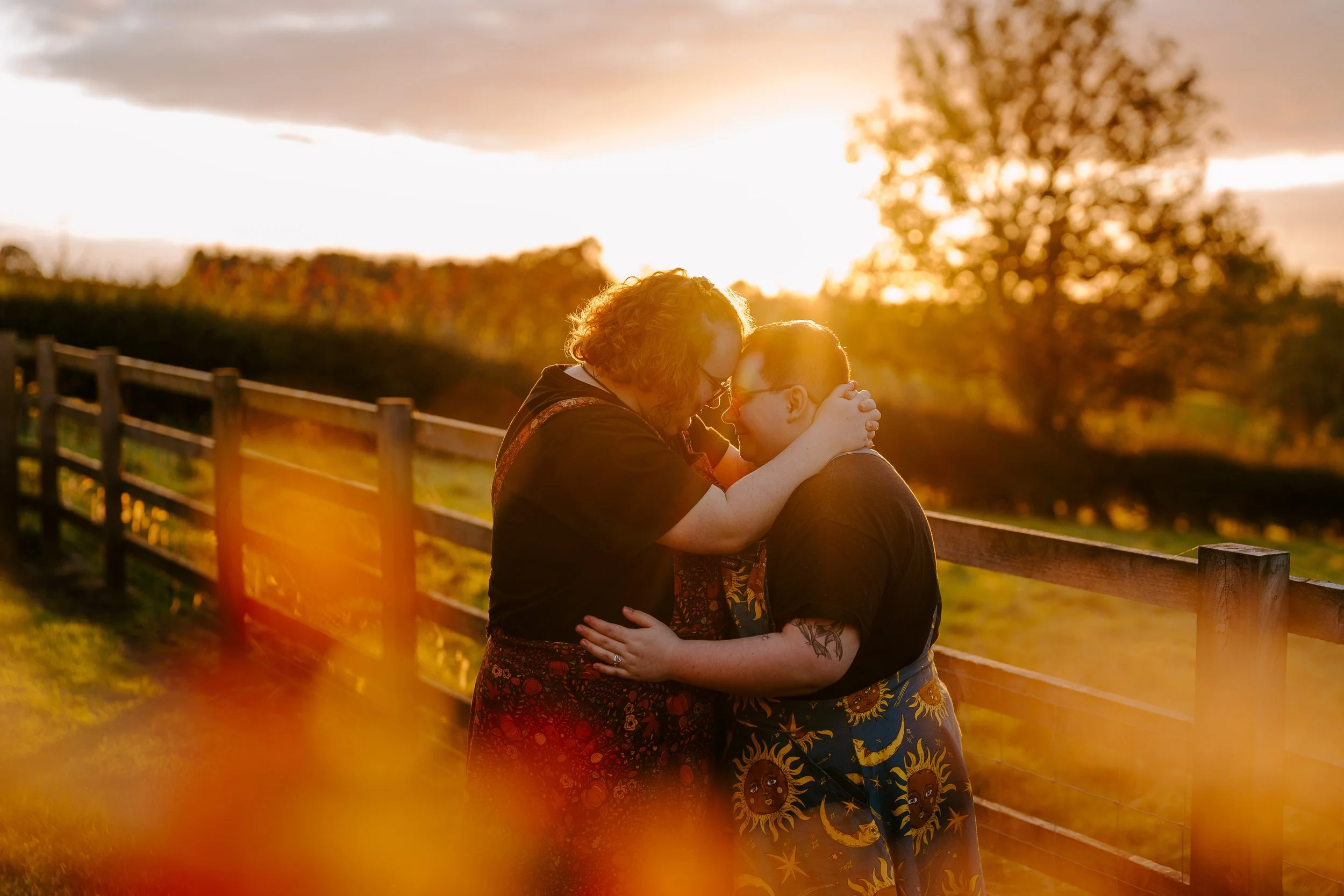 A neurodivergent couple having a cuddle on their October wedding day at golden hour