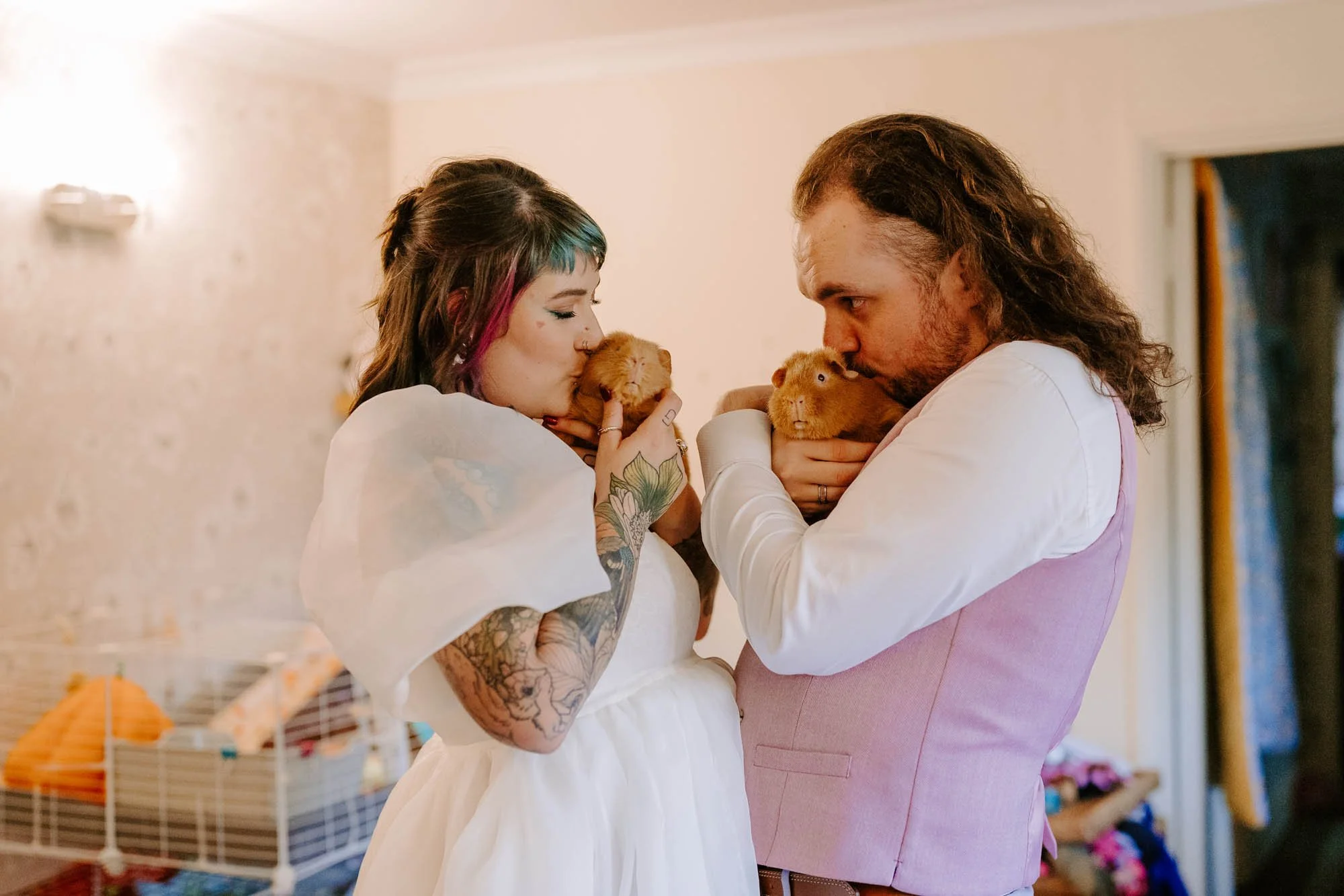 A bride and groom kissing thier guinea pigs