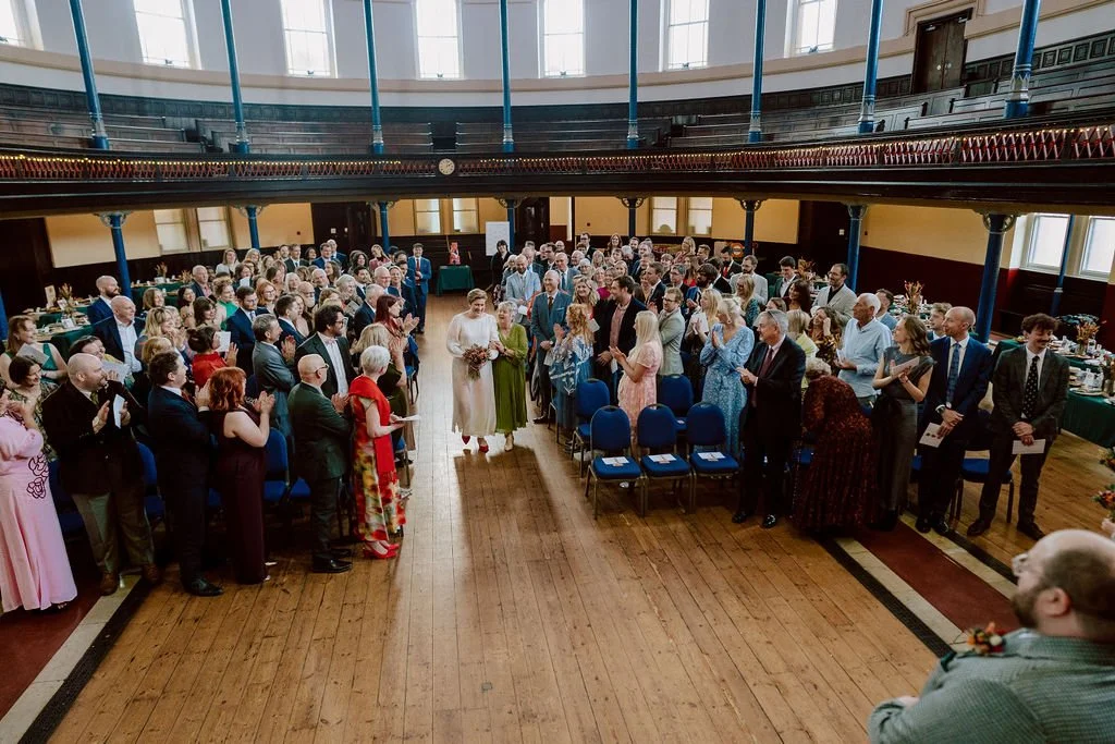 a bride and her mum walk down the aisle at hackney round chapel