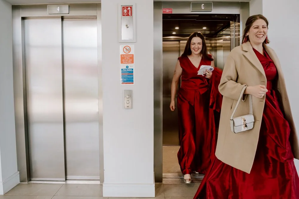 two brides exit a lift to their ceremony