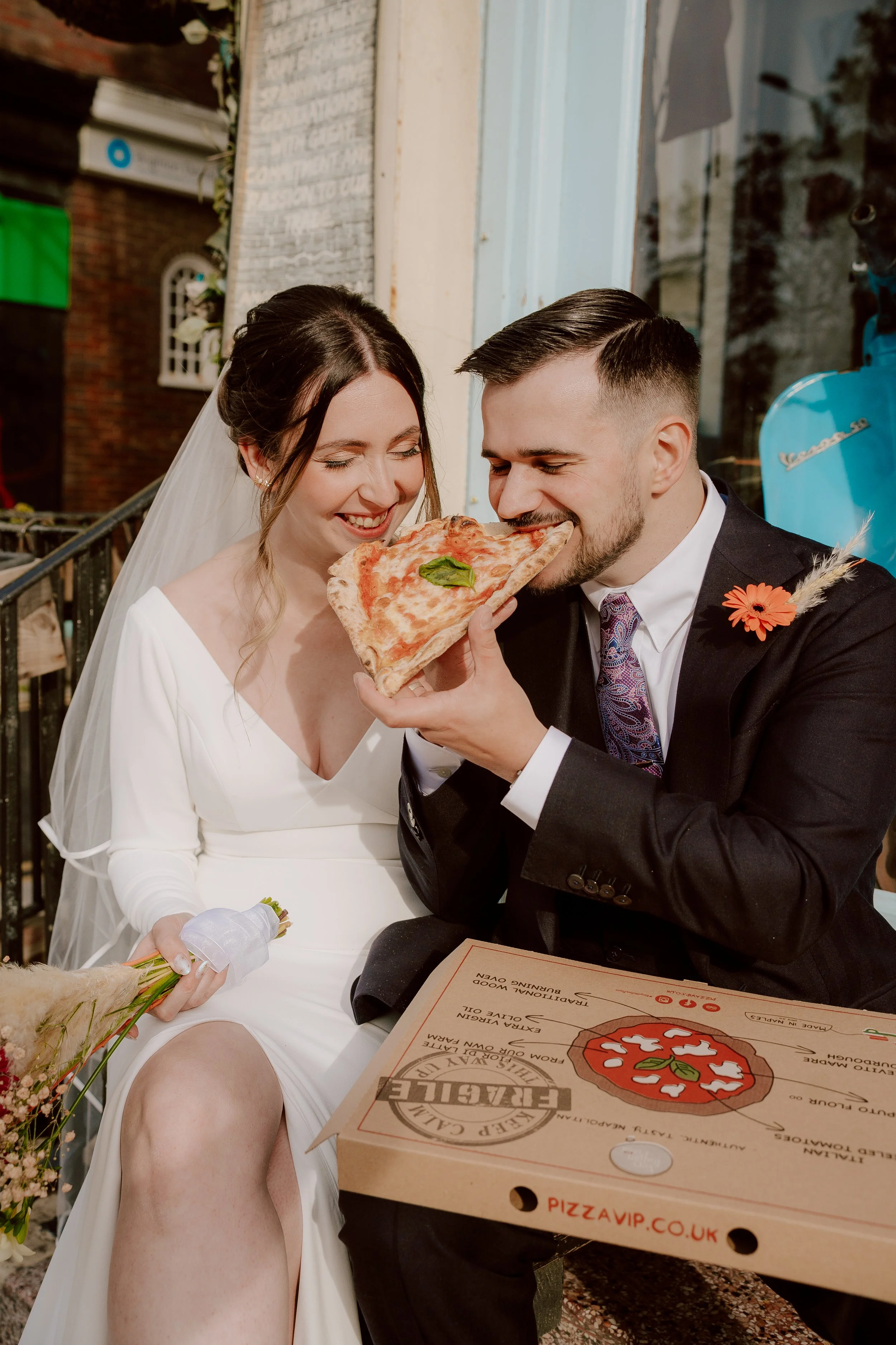 Bride and Groom eating pizza in Brighton at their October Wedding