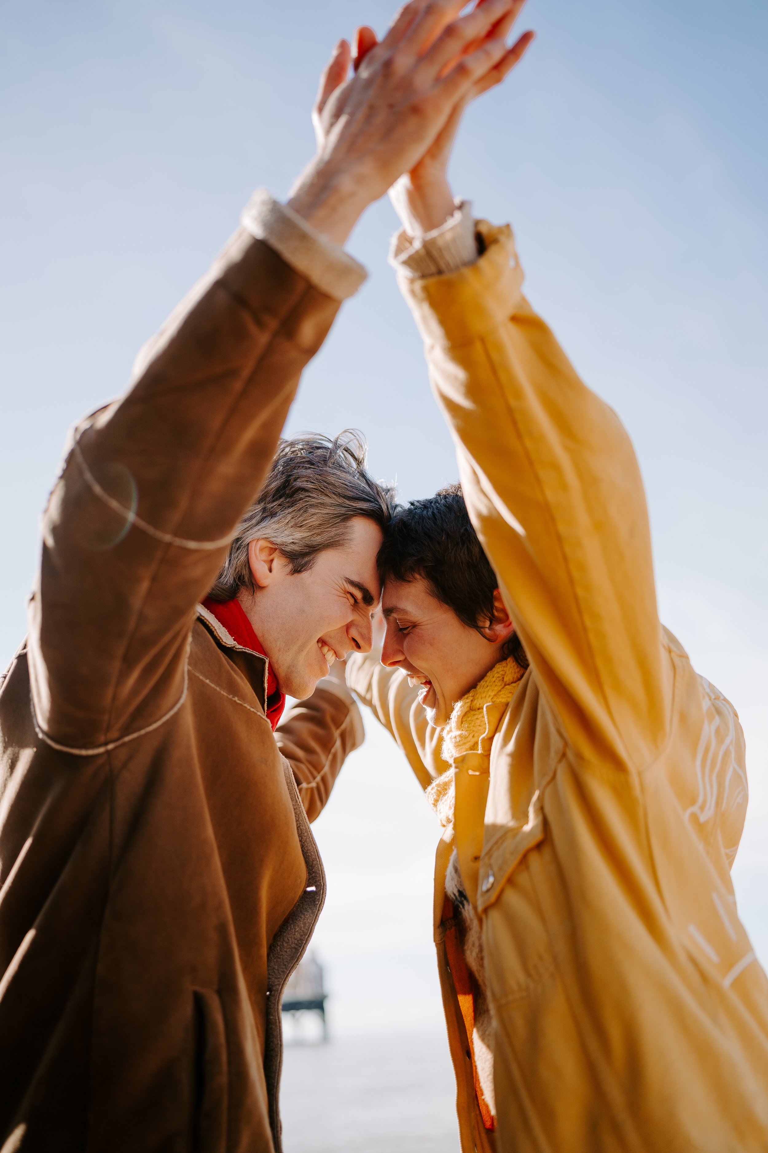 queer couple laughing on brighton beach