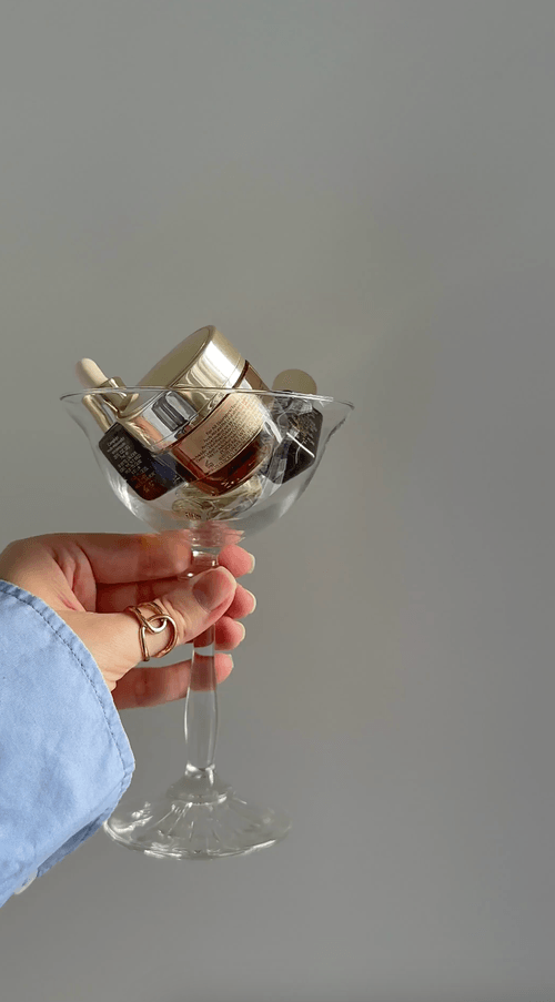 Hand holding a glass styled with dried flowers