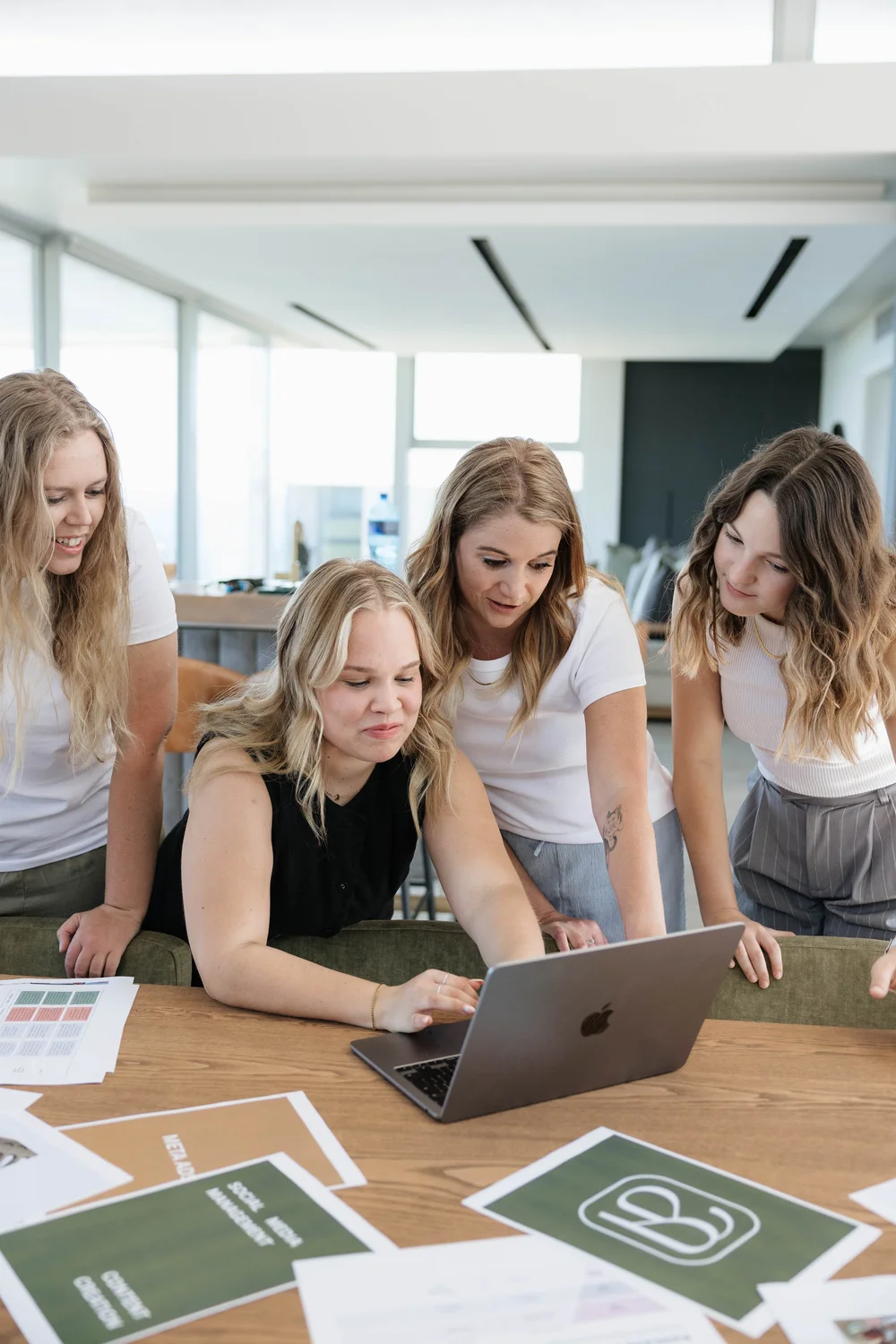 The Epic Blue Social team gathered around a laptop