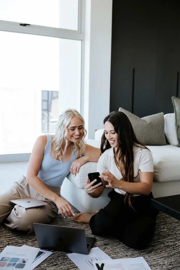 Two team members reviewing content on a phone