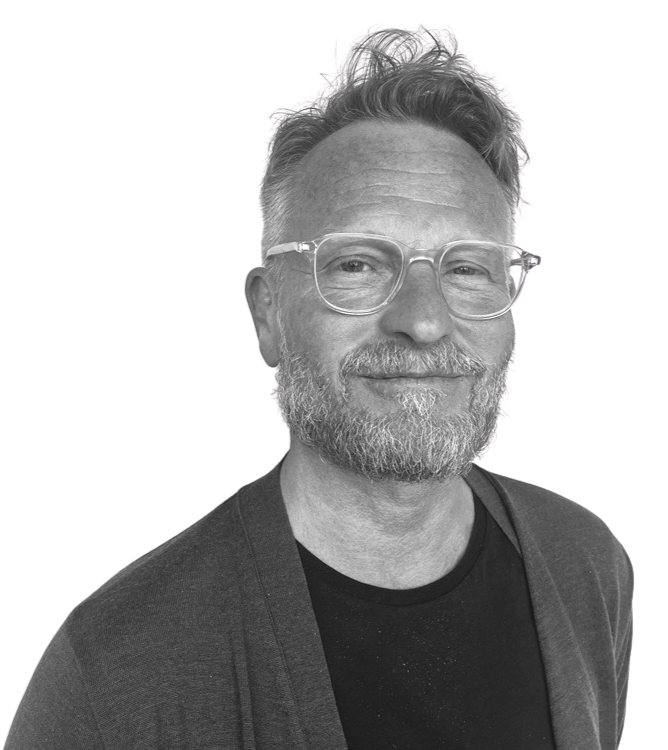 Portrett av en mann med grått skjegg og briller