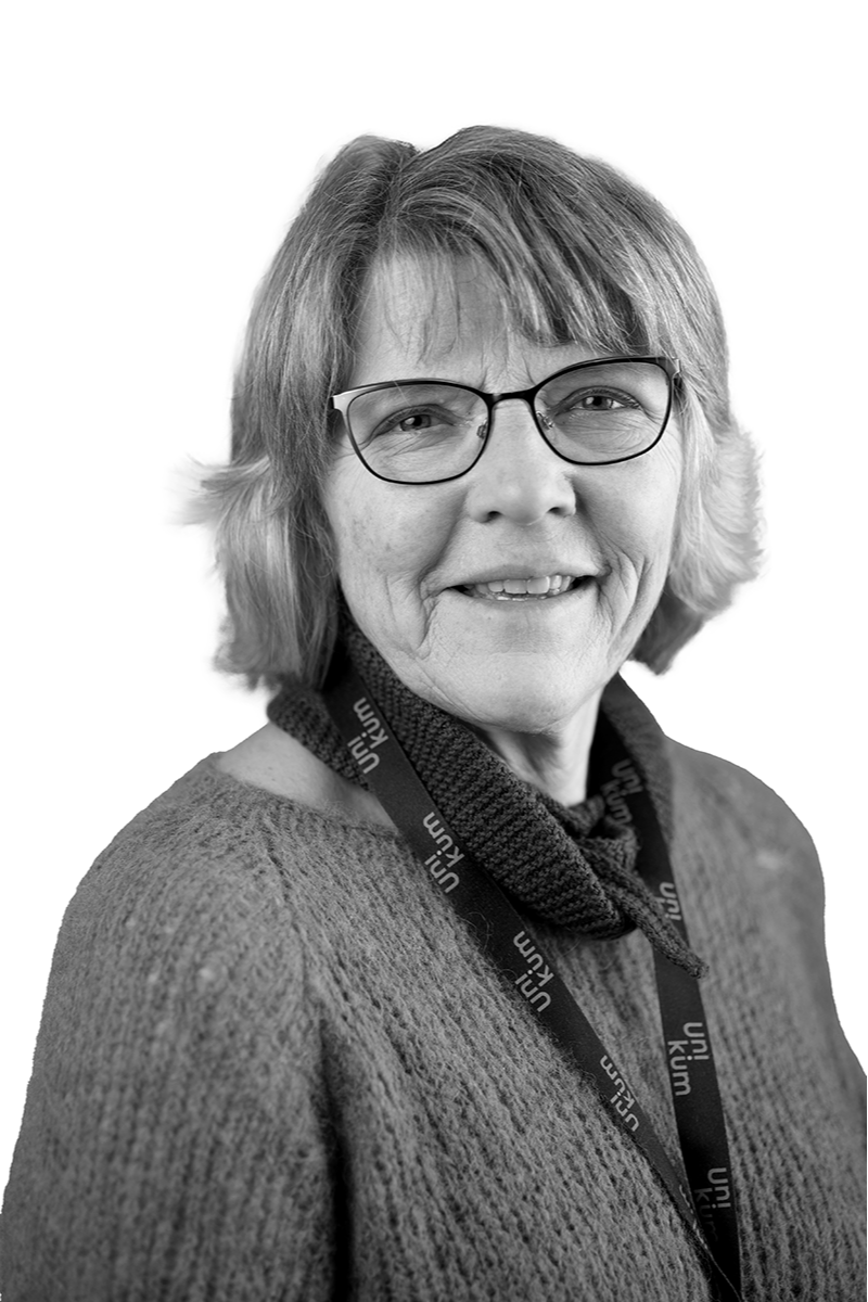 En kvinne med kort, grått hår og briller