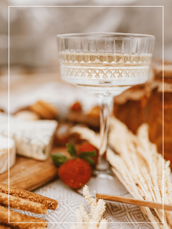 Coupe de champagne, épis de blé et nourriture sur table