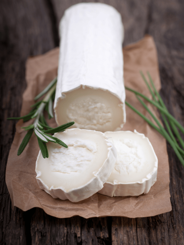 Goat cheese on a craft paper on a wooden table top