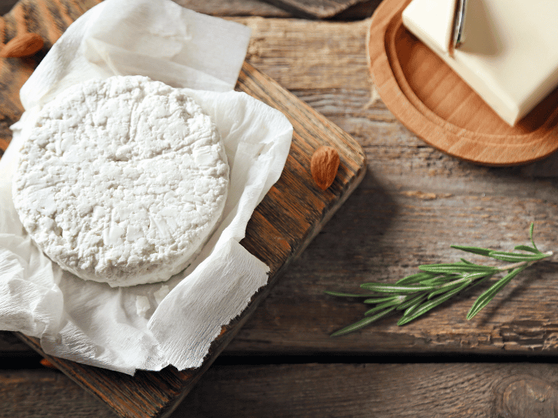 Goat cheese on a wooden board and wooden table
