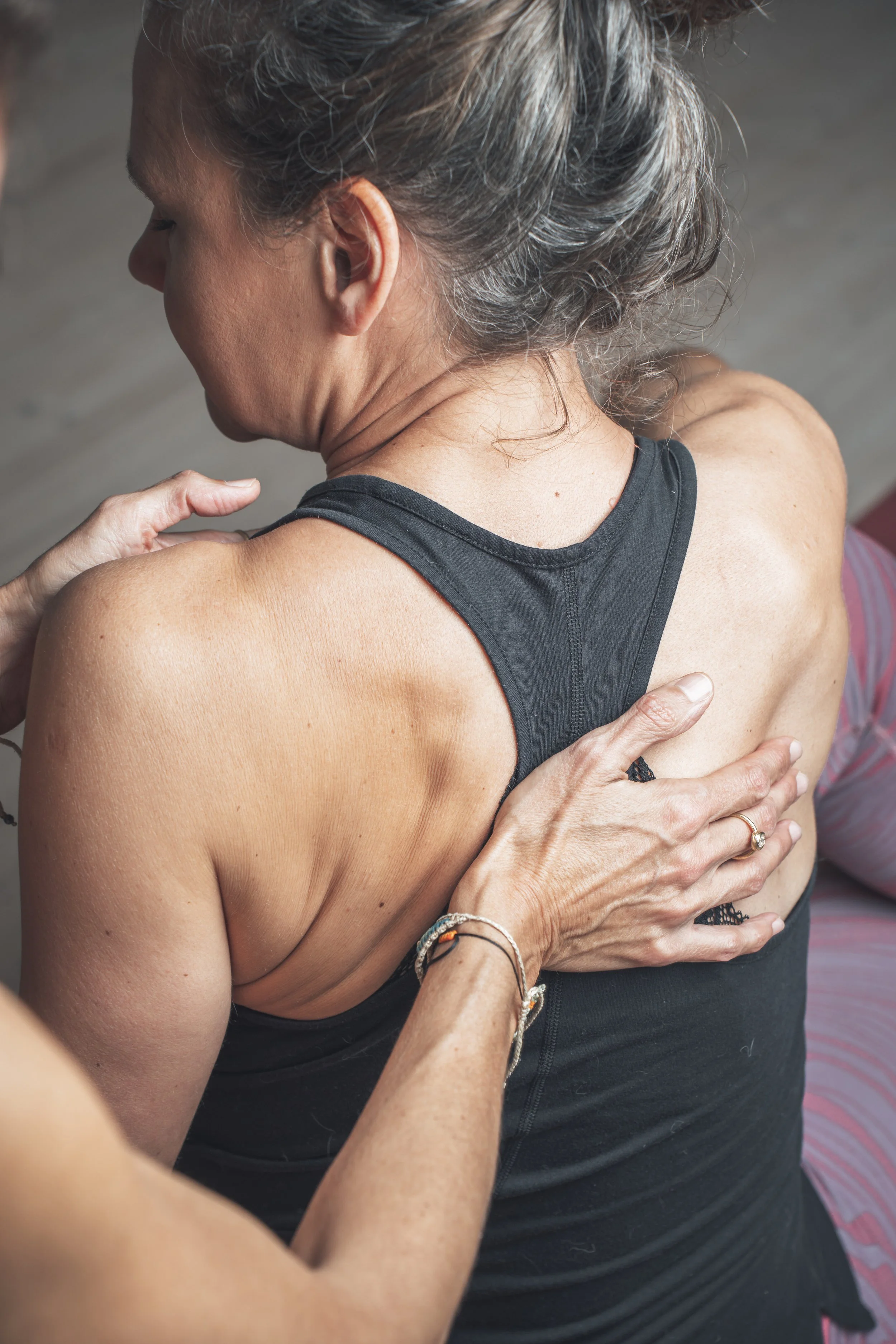 Eine Frau erhält eine Massage an der Schulter und im oberen Rückenbereich.