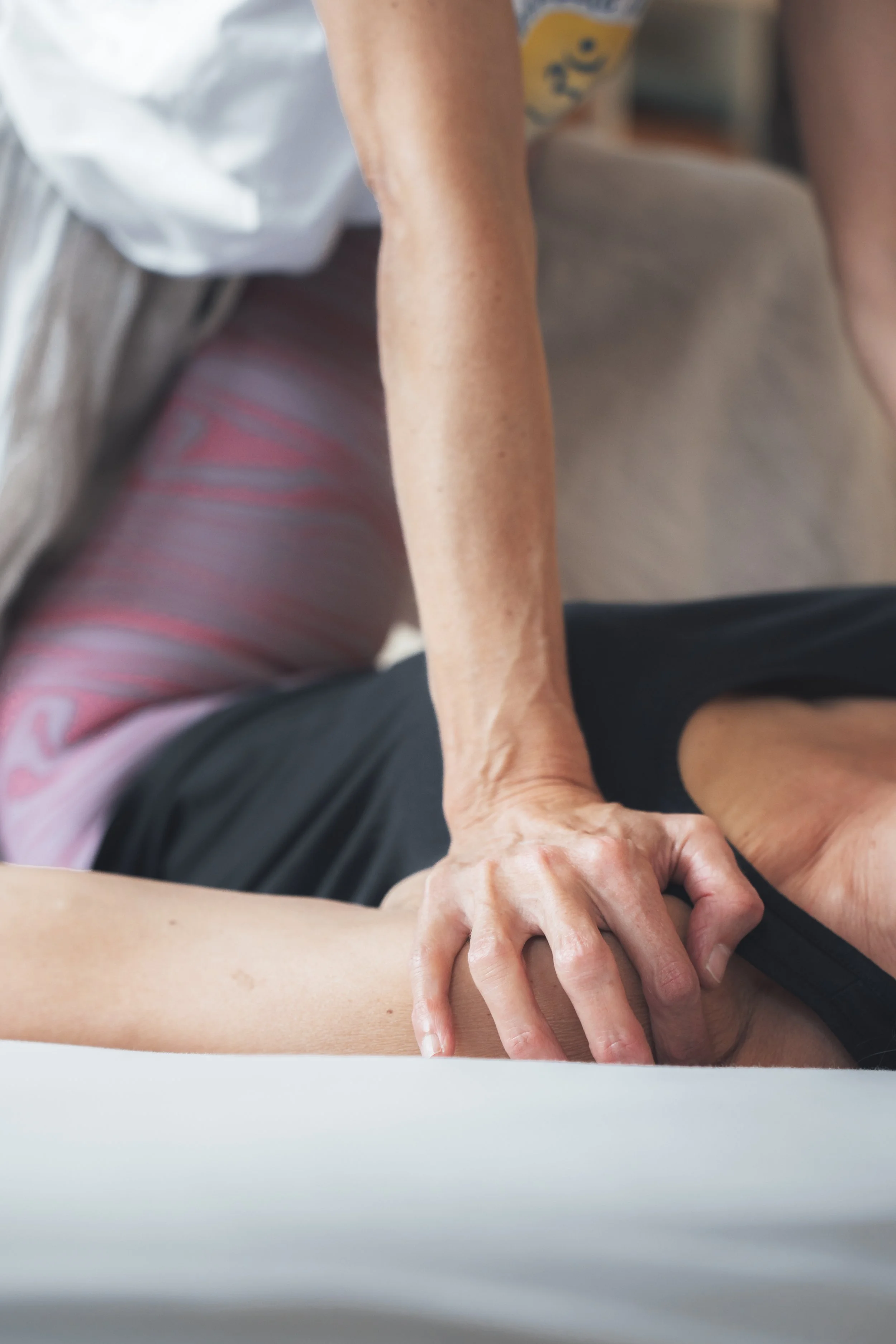 Therapeutische Massage mit Handdruck an der Schulter einer Kundin