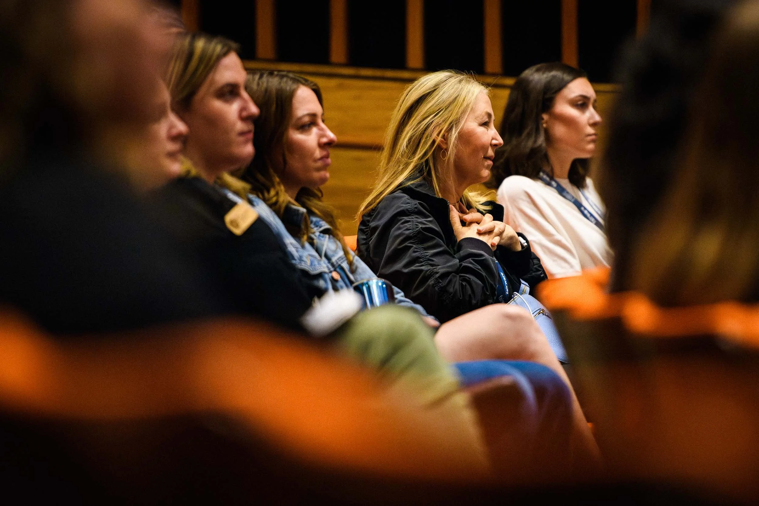 Conference attendees seated in an auditorium listening attentively during a keynote