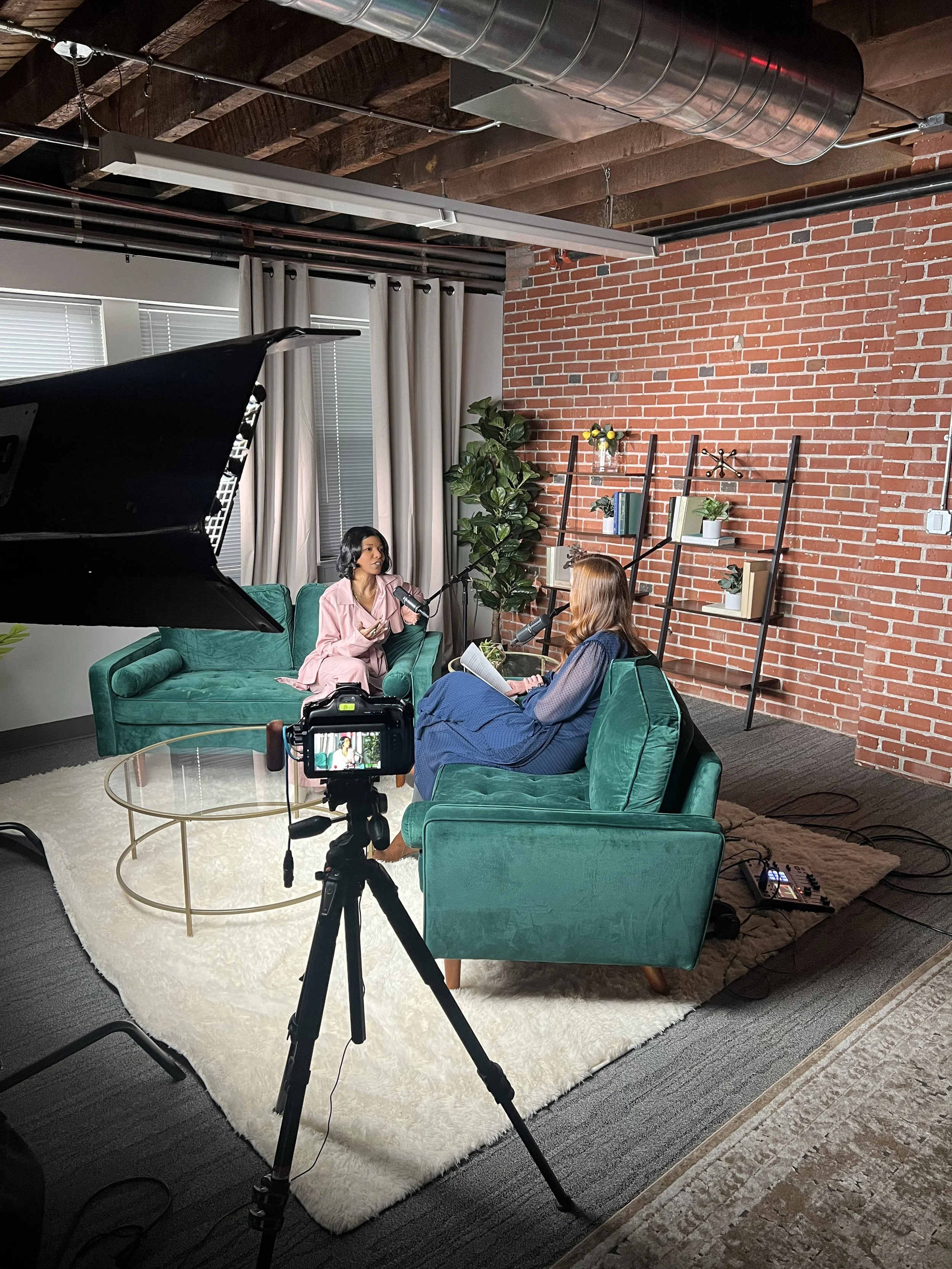 Kimberly McGlonn recording an interview in a podcast studio with cameras and microphones