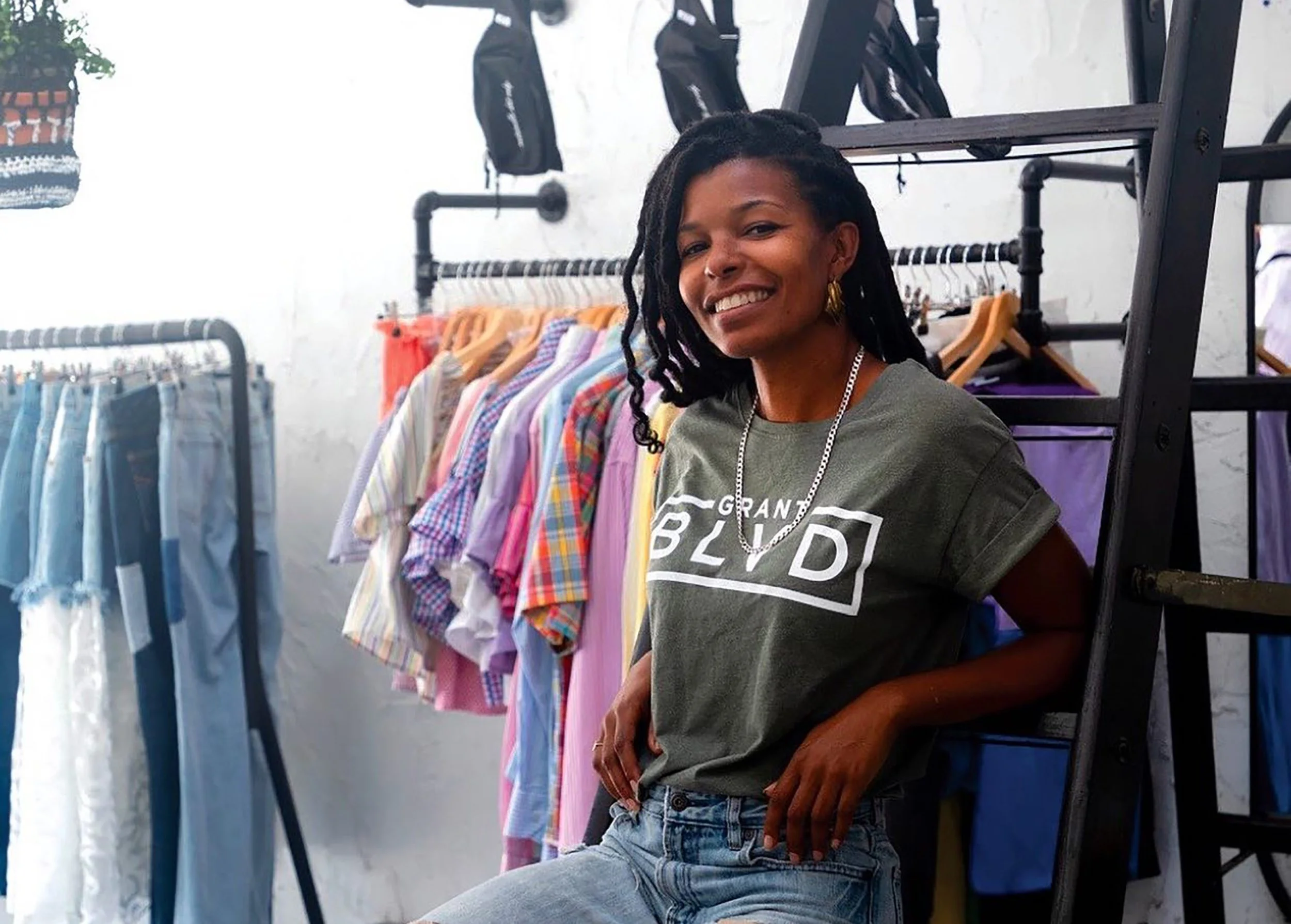 Kimberly McGlonn inside the Grant Blvd boutique surrounded by clothing racks