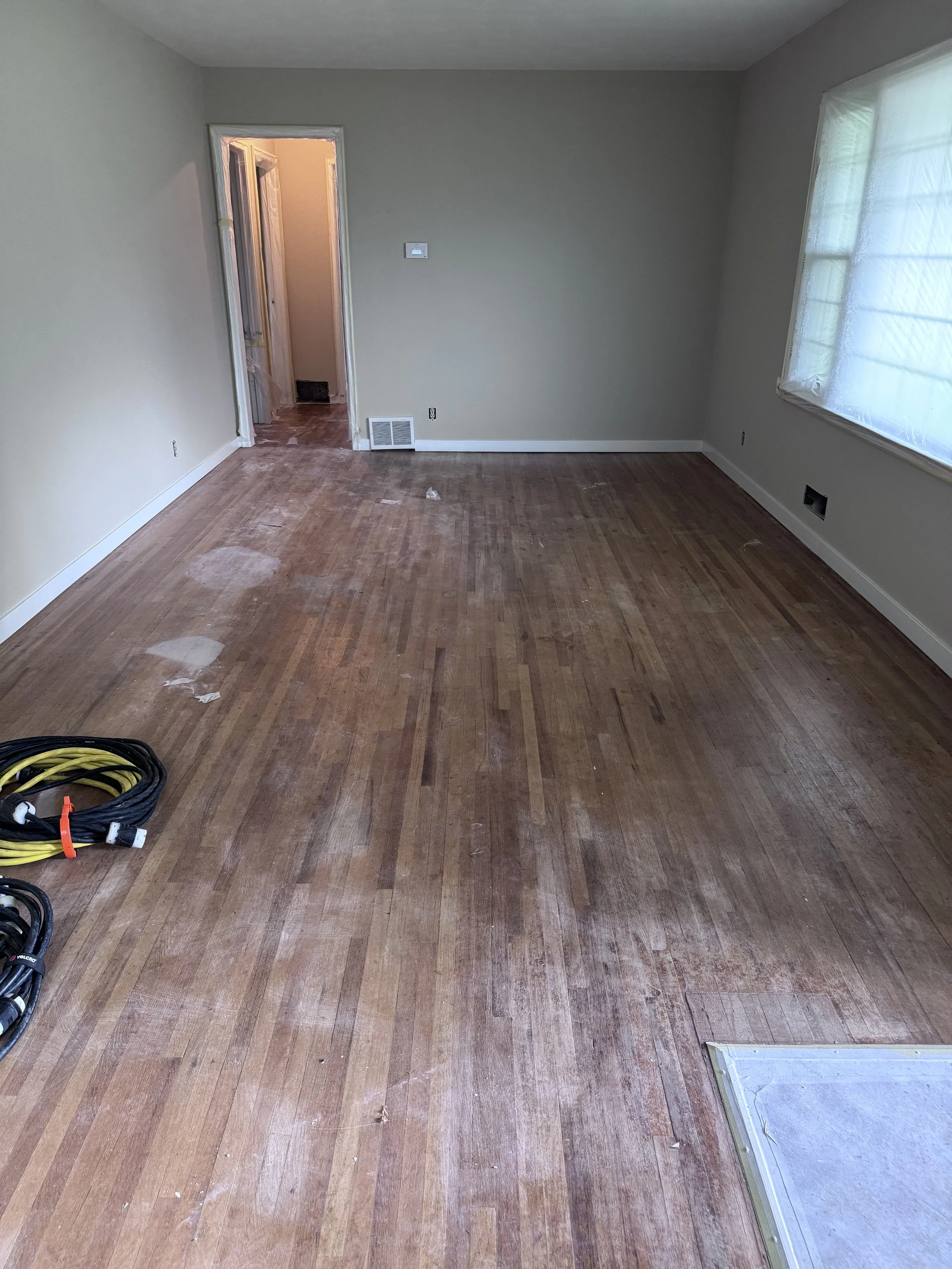 front entry view living room worn floors.jpeg