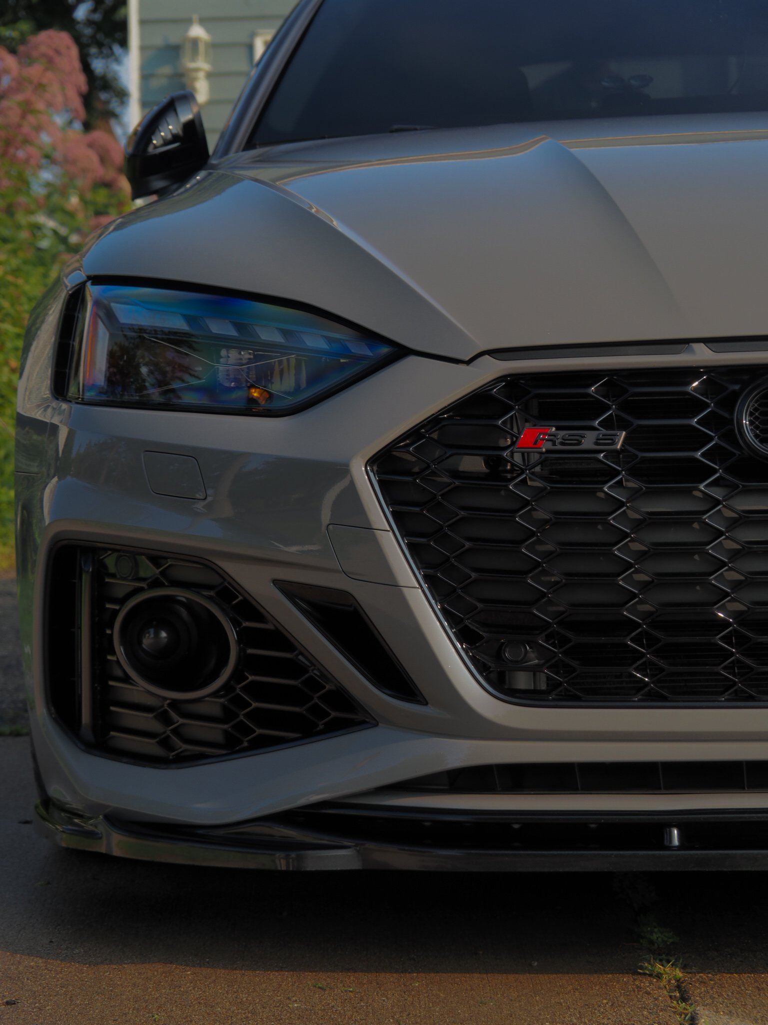 Front view of a gray Audi RS5 with prominent grille and headlight details.